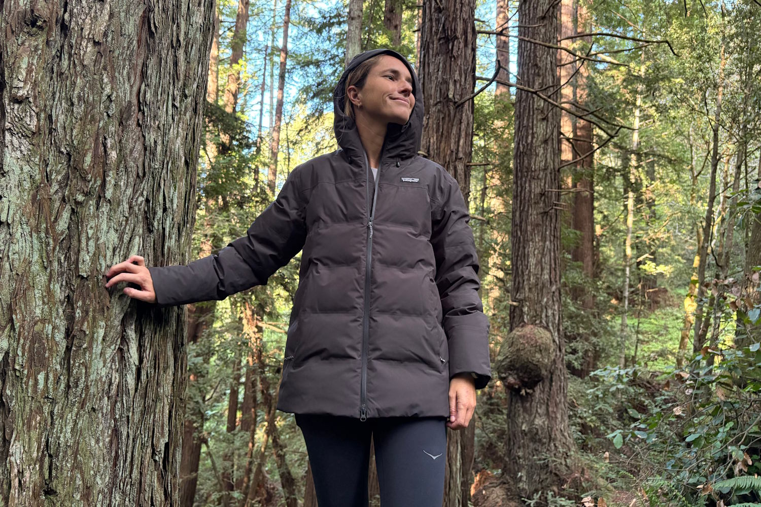 Women wearing a patagonia glacier jacket stands in a forest