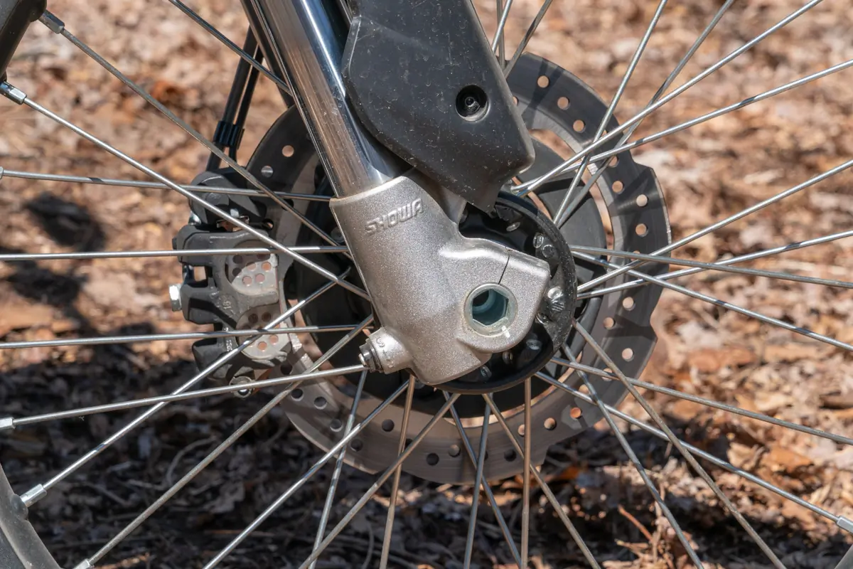 A close-up of the Zero FX electric motorcycle's front brake disc and suspension fork