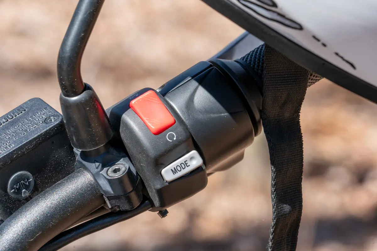 A close-up of the mode switch on the Zero FX electric motorcycle's handlebars, showing the mode and other control buttons