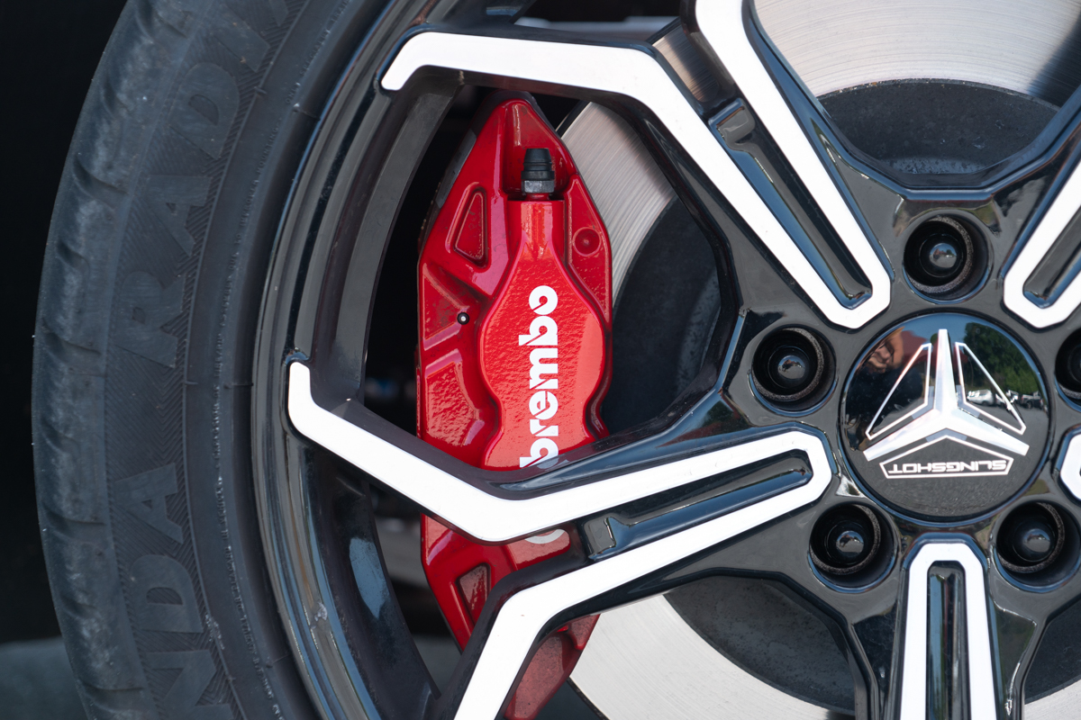 Polaris Slingshot R close-up of black alloy wheel with red Brembo brake caliper and Slingshot logo center cap