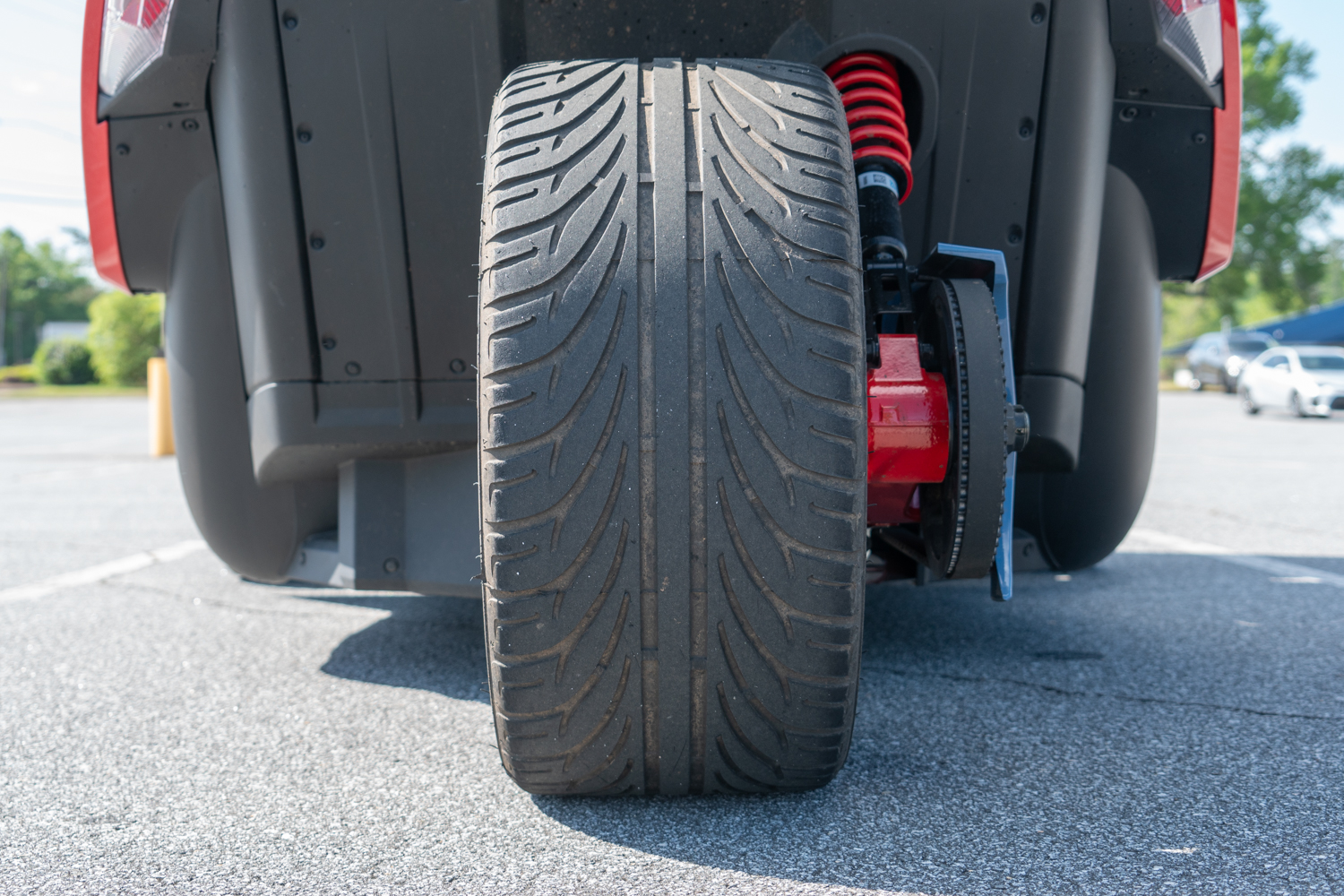 Polaris Slingshot R close-up of the single rear tire, red suspension coil, and brake system