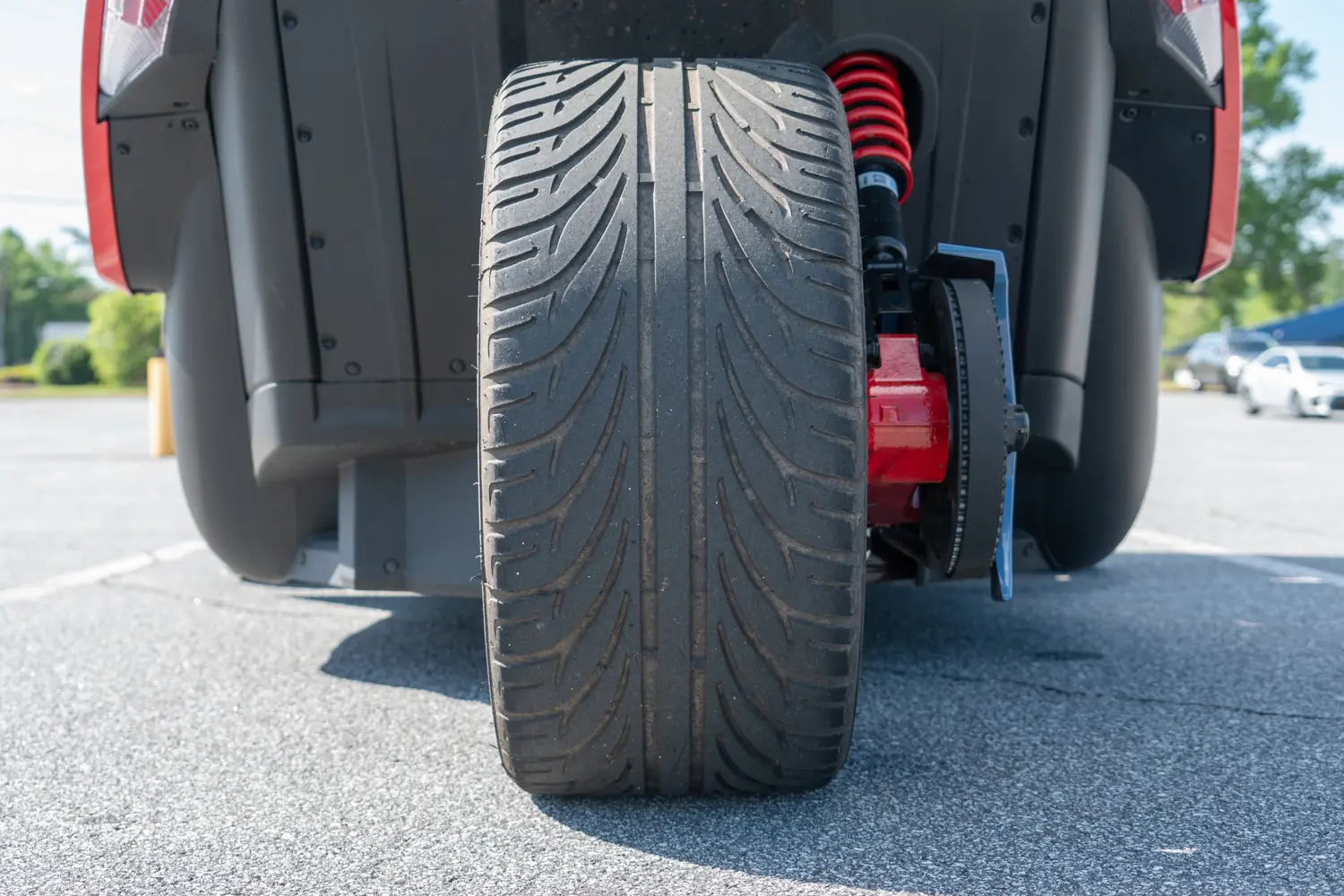 Polaris Slingshot R close-up of the single rear tire, red suspension coil, and brake system