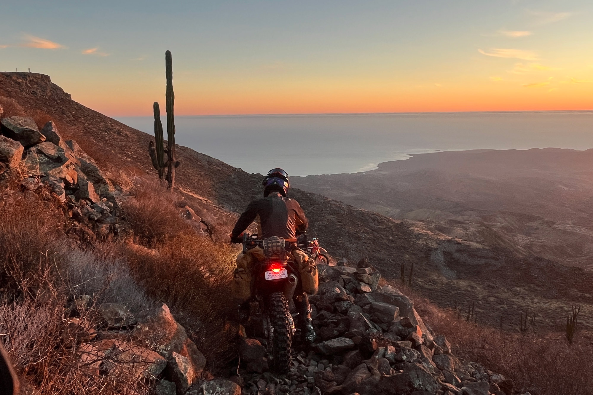 Mosko Moto Reckless 40L System V4.0 on a bike navigating rocky terrain at sunset
