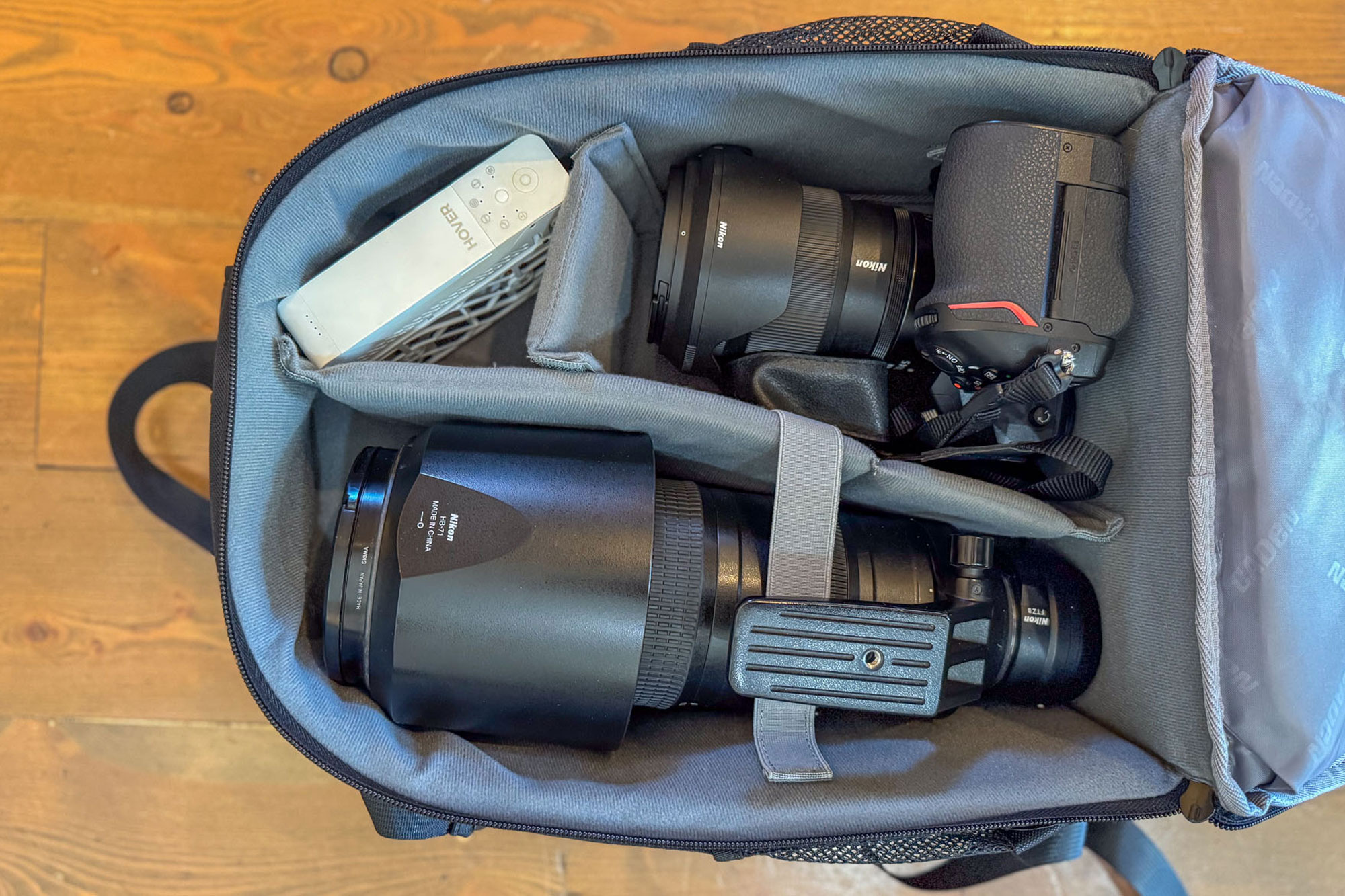 CADeN Camera Backpack open on the wooden floor