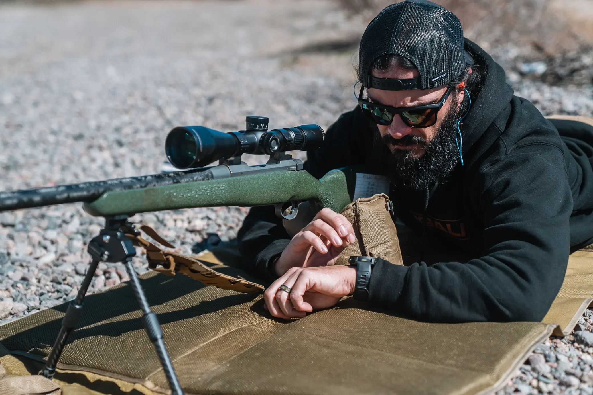 Garmin Tactix 8 Smartwatch checked during prone rifle shooting setup