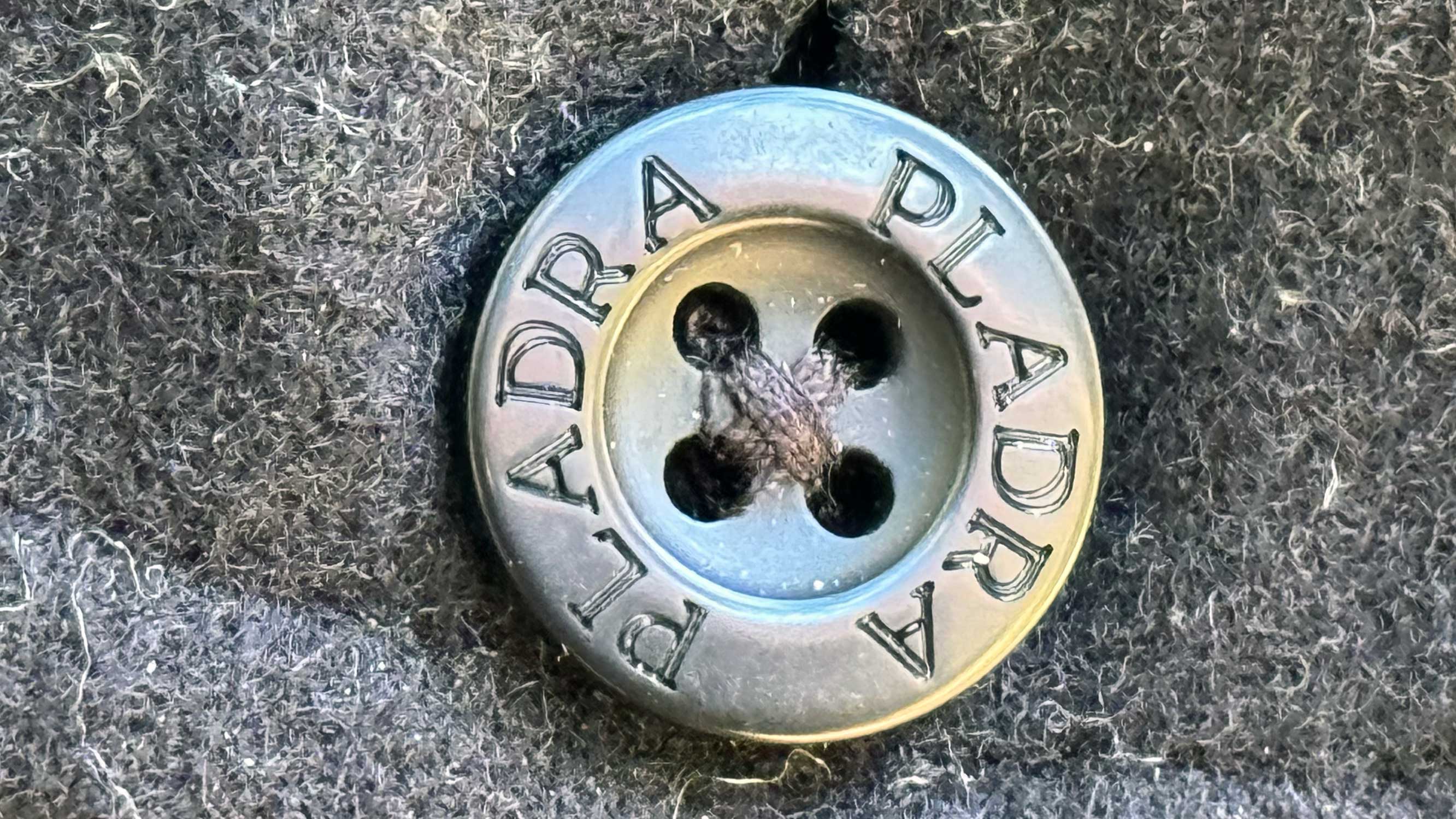 a detail image of the buttons on the workhorse wool, showing the cross-stitch that attaches them