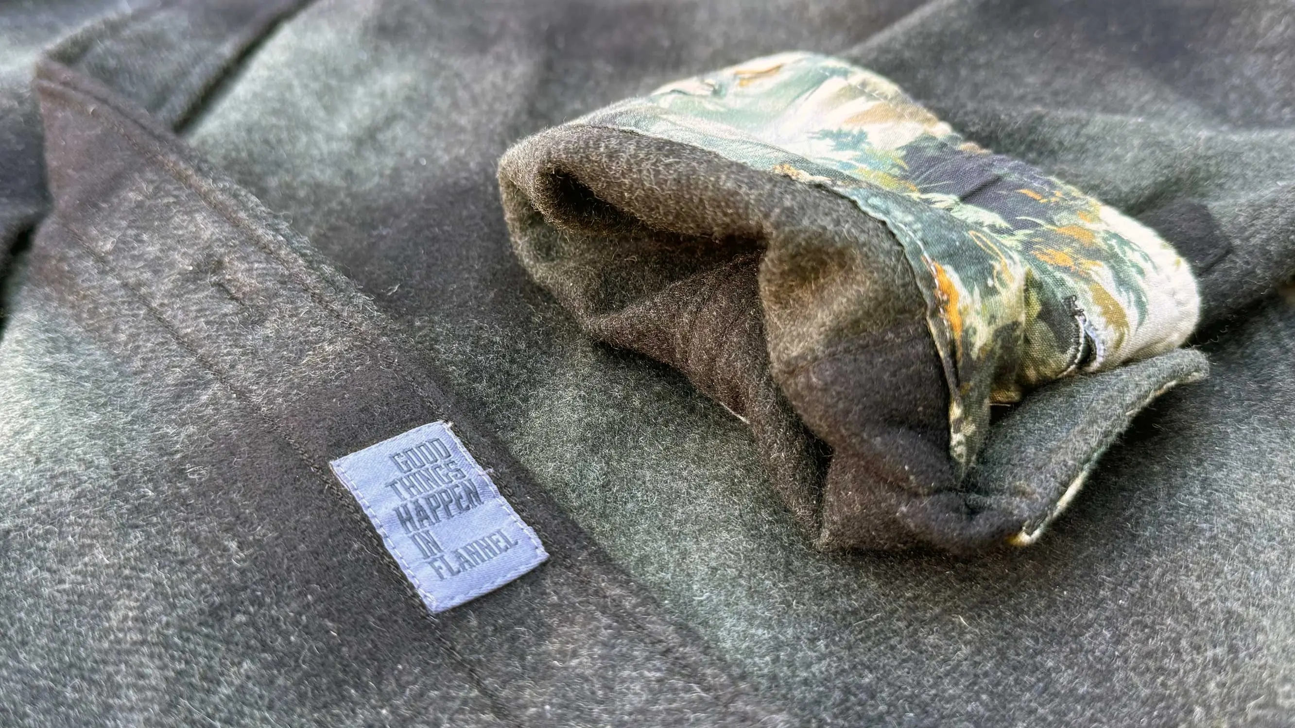 a tight image showing the rolled back cuff of the workhorse wool shirt, highlighting the interior pattern