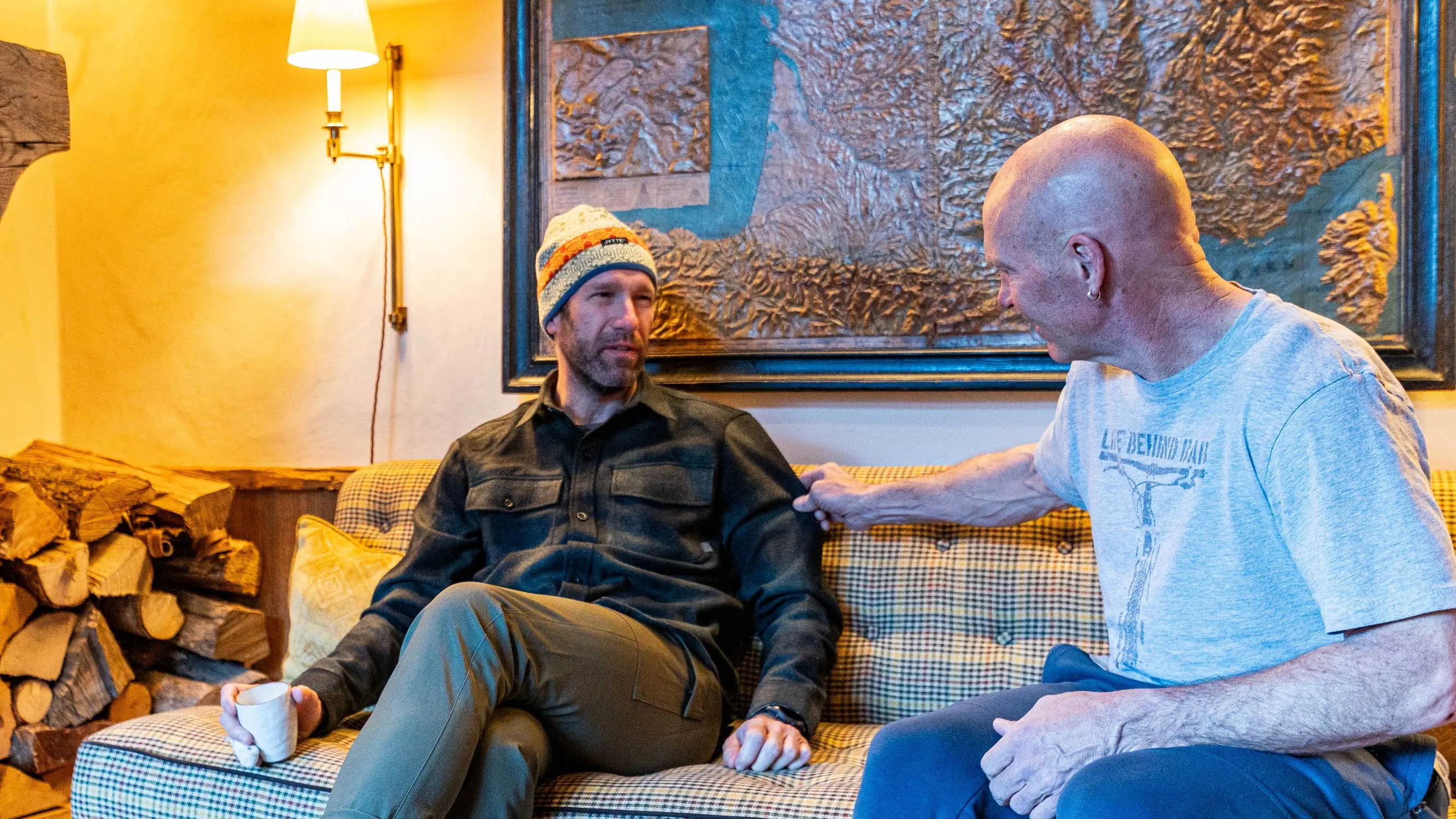the author sits on a couch in the french chalet after skiing, while wearing the workhorse wool flannel