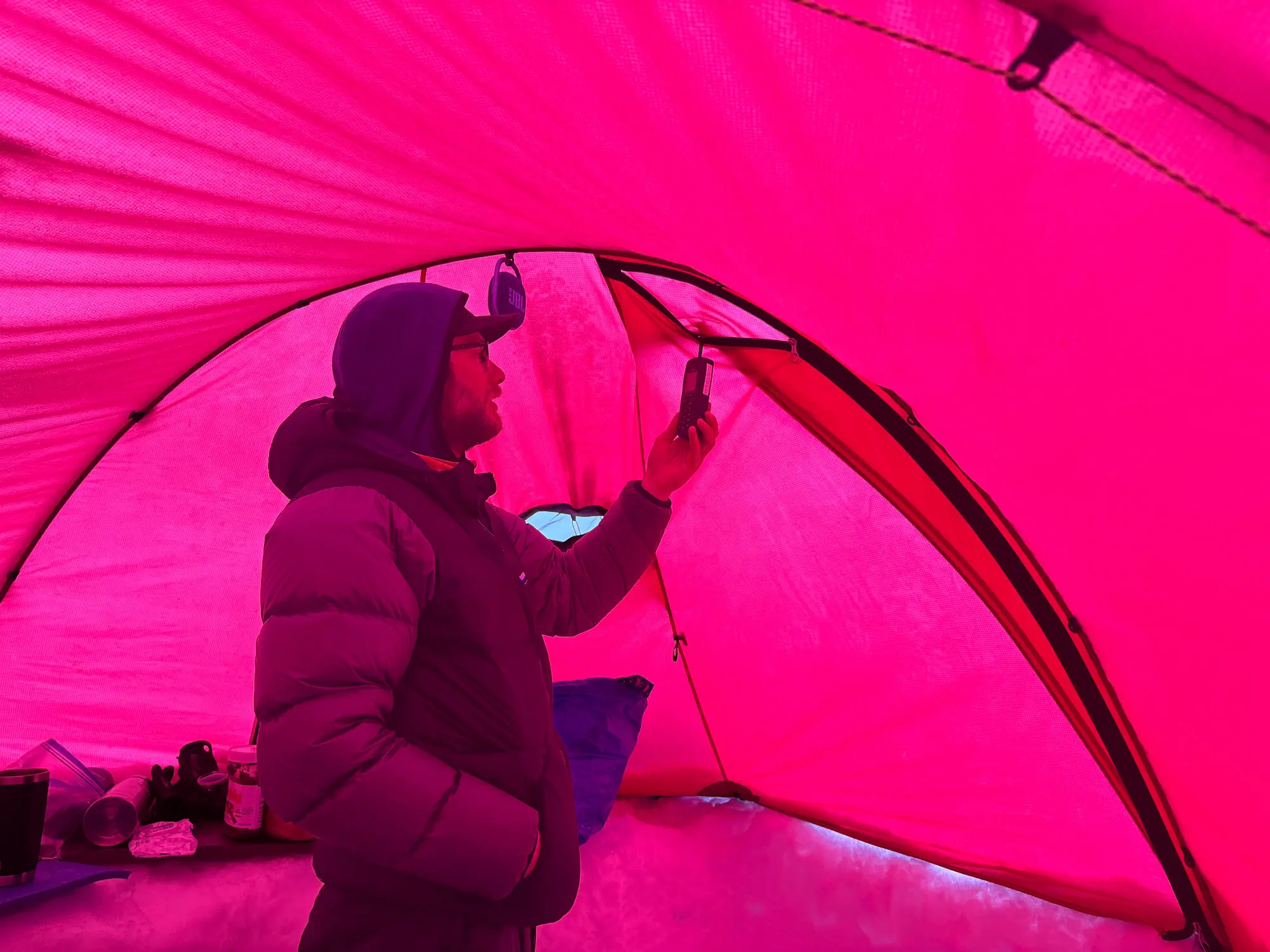 a climber exposes the antenna of the iridium 9555 phone to get better reception from inside his basecamp tent
