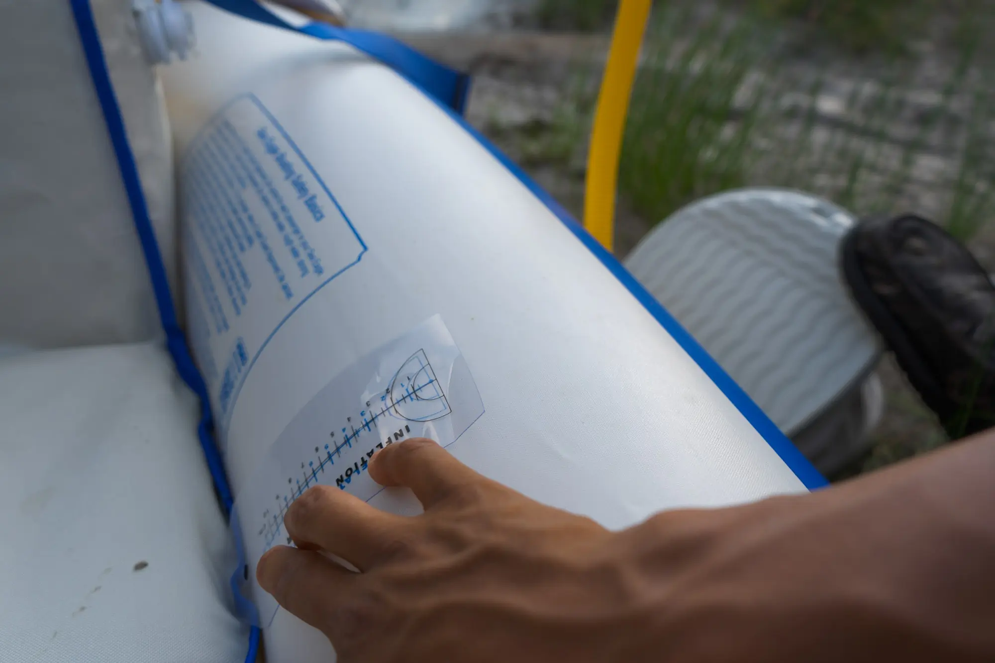 A paddler measures the inflation of the SE370 by using the included sticker