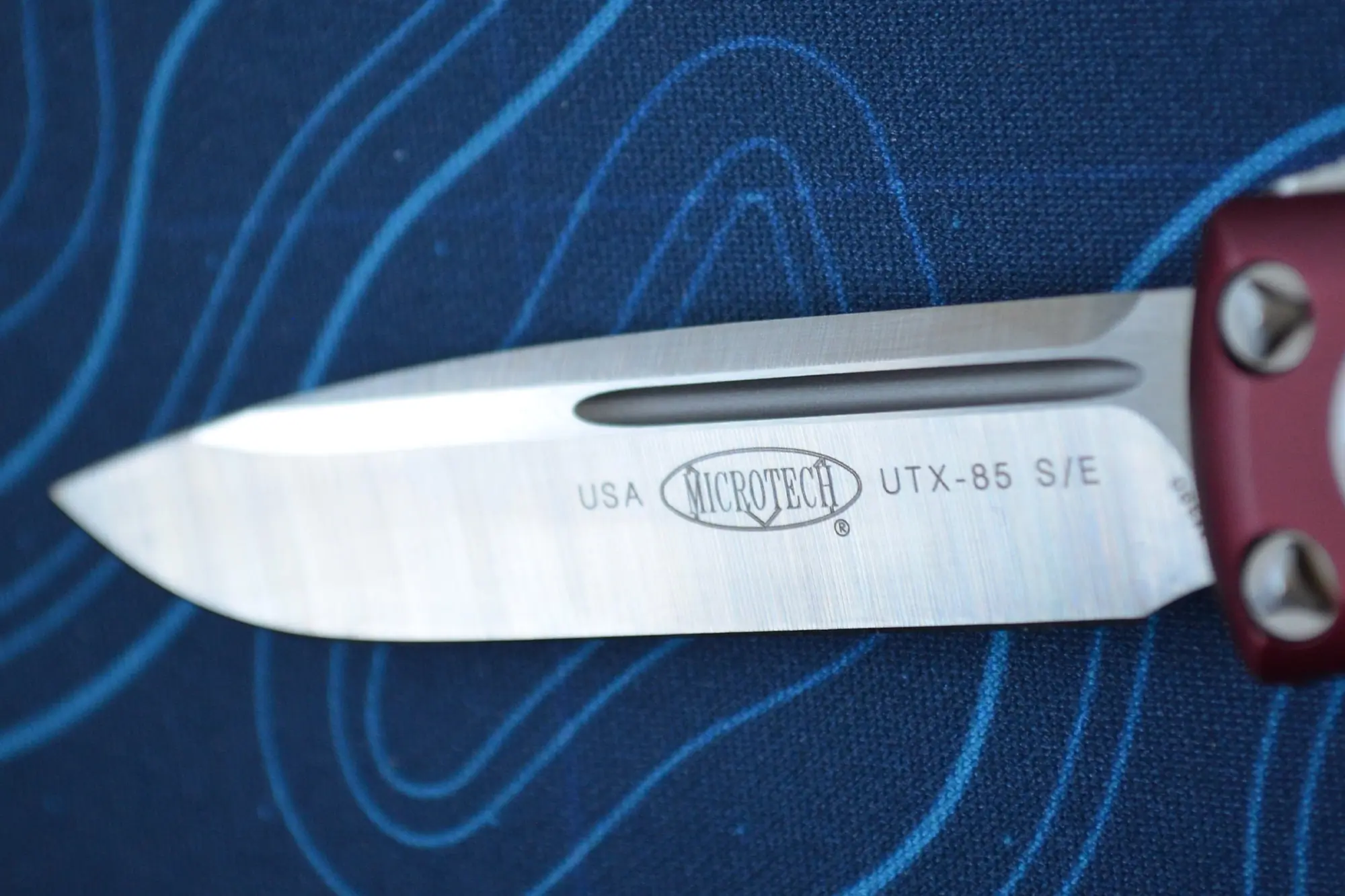 Microtech UTX-85 blade close-up with logo and markings