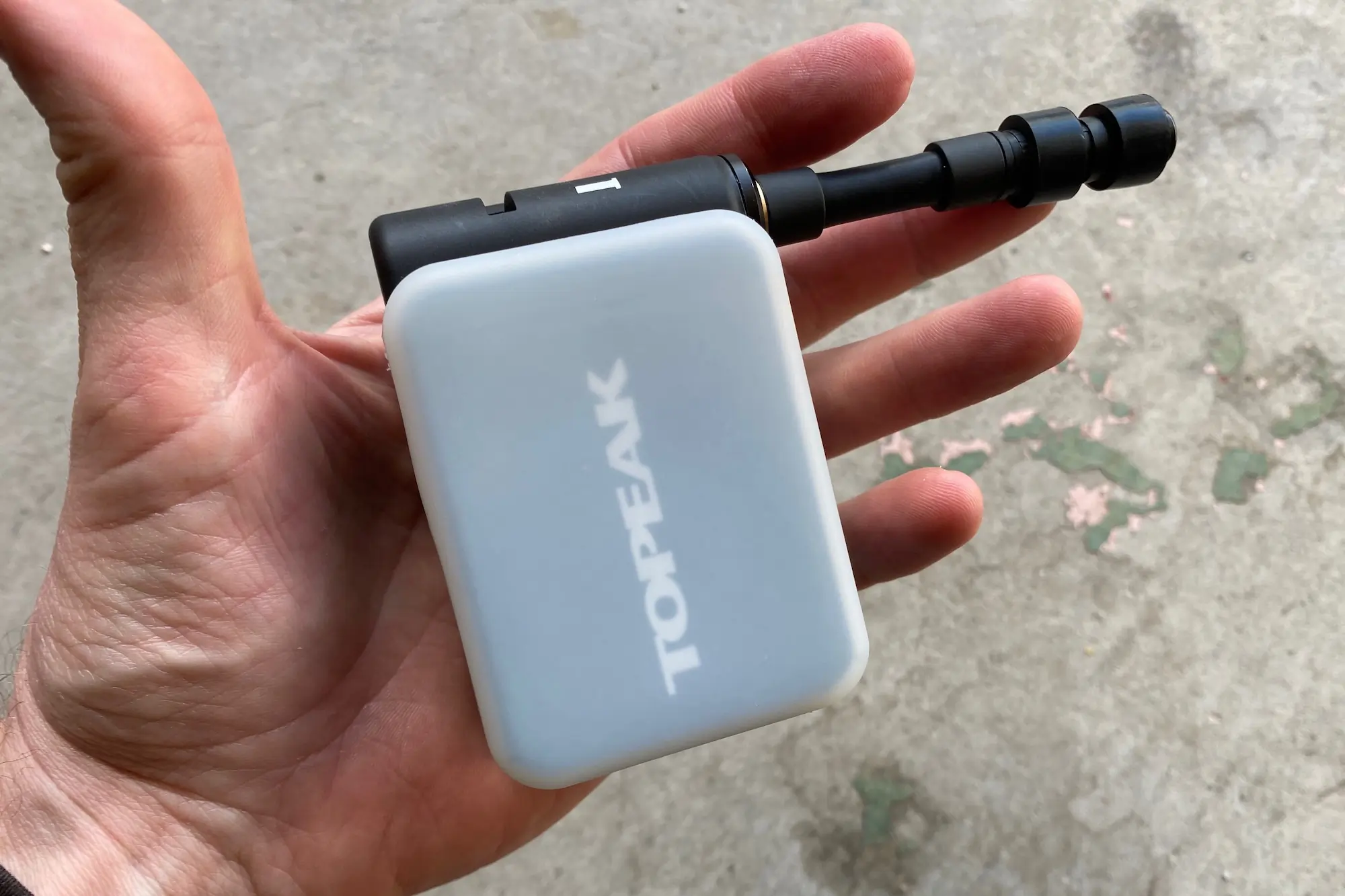 Holing the Topeak E-Booster Digital electric bike pump to demonstrate its size