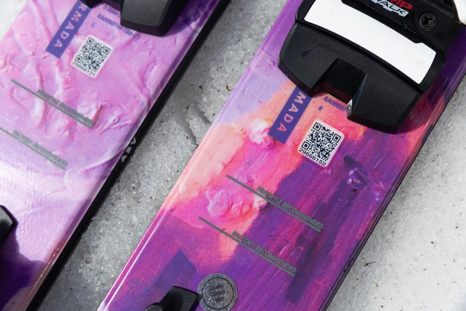 Close-up of Armada ARV 100 skis showing the factory recommended and freestyle recommended mount points marked on the topsheet near the bindings