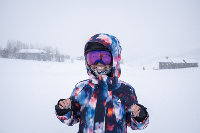 Women wearing pink goggles and a Burton snow jacket standing in a snowy landscape