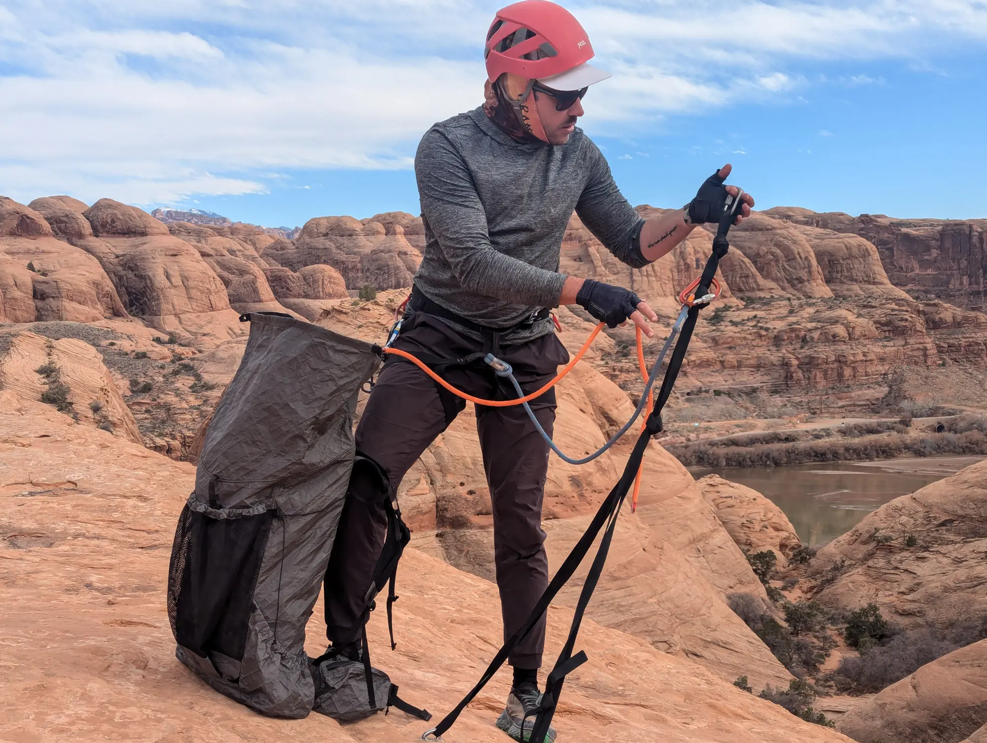 the author feeds rope out of the kawka 55 pack and sets up an anchor in canyonlands