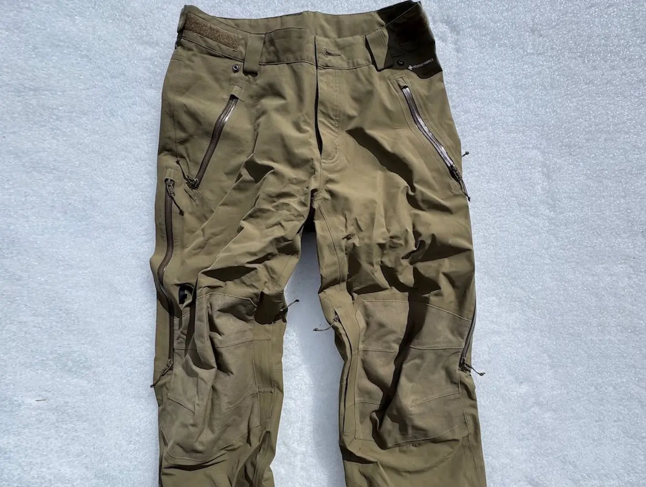 Flylow chemical pants lying on snow