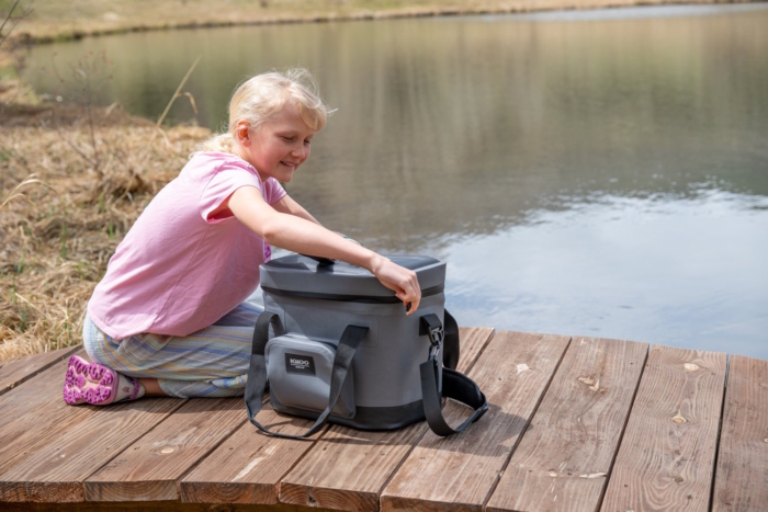 Girl by Lake Opening Igloo Cooler on Dock