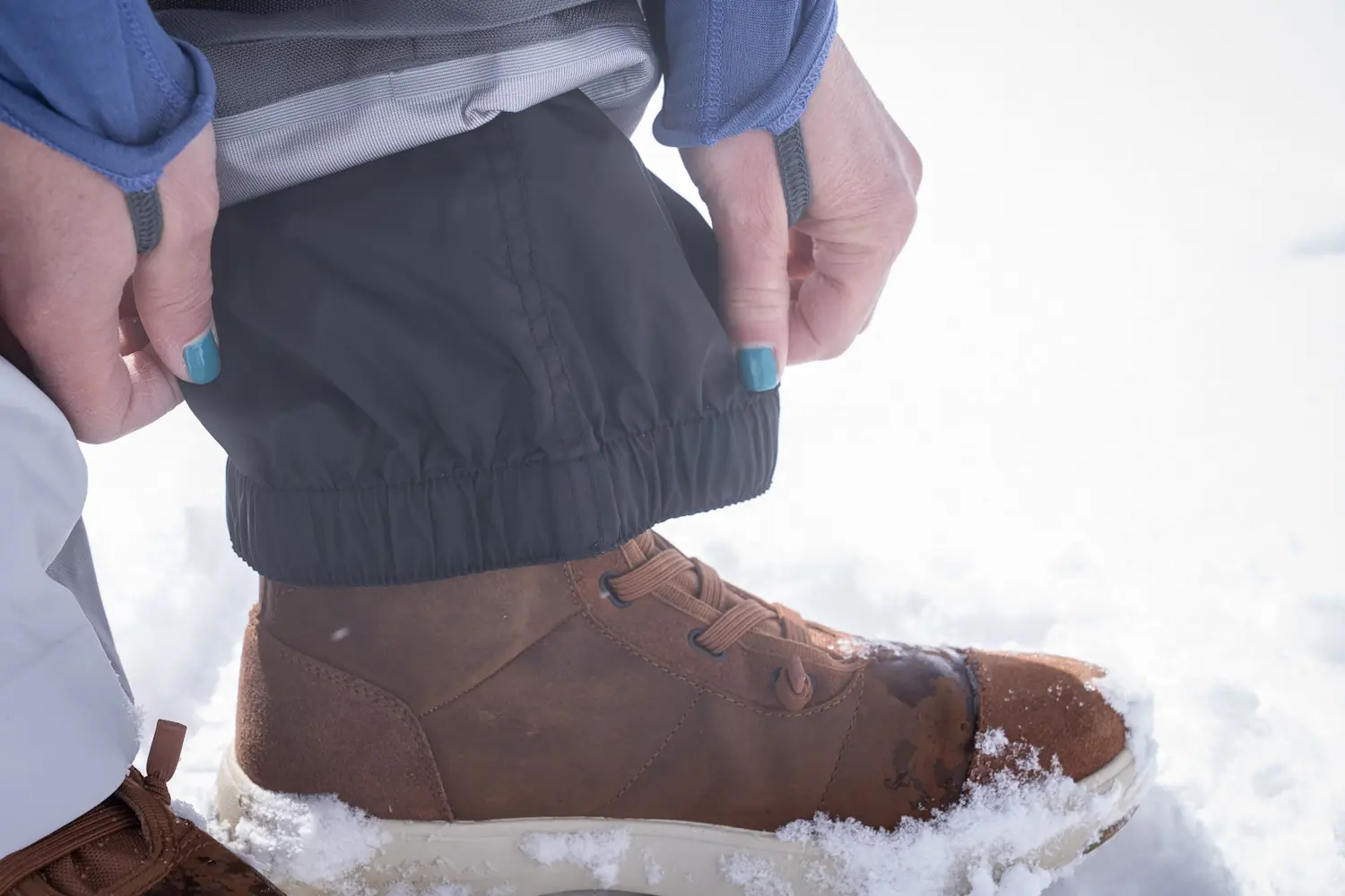Close-up of a person adjusting the elastic gaiter of ski pants