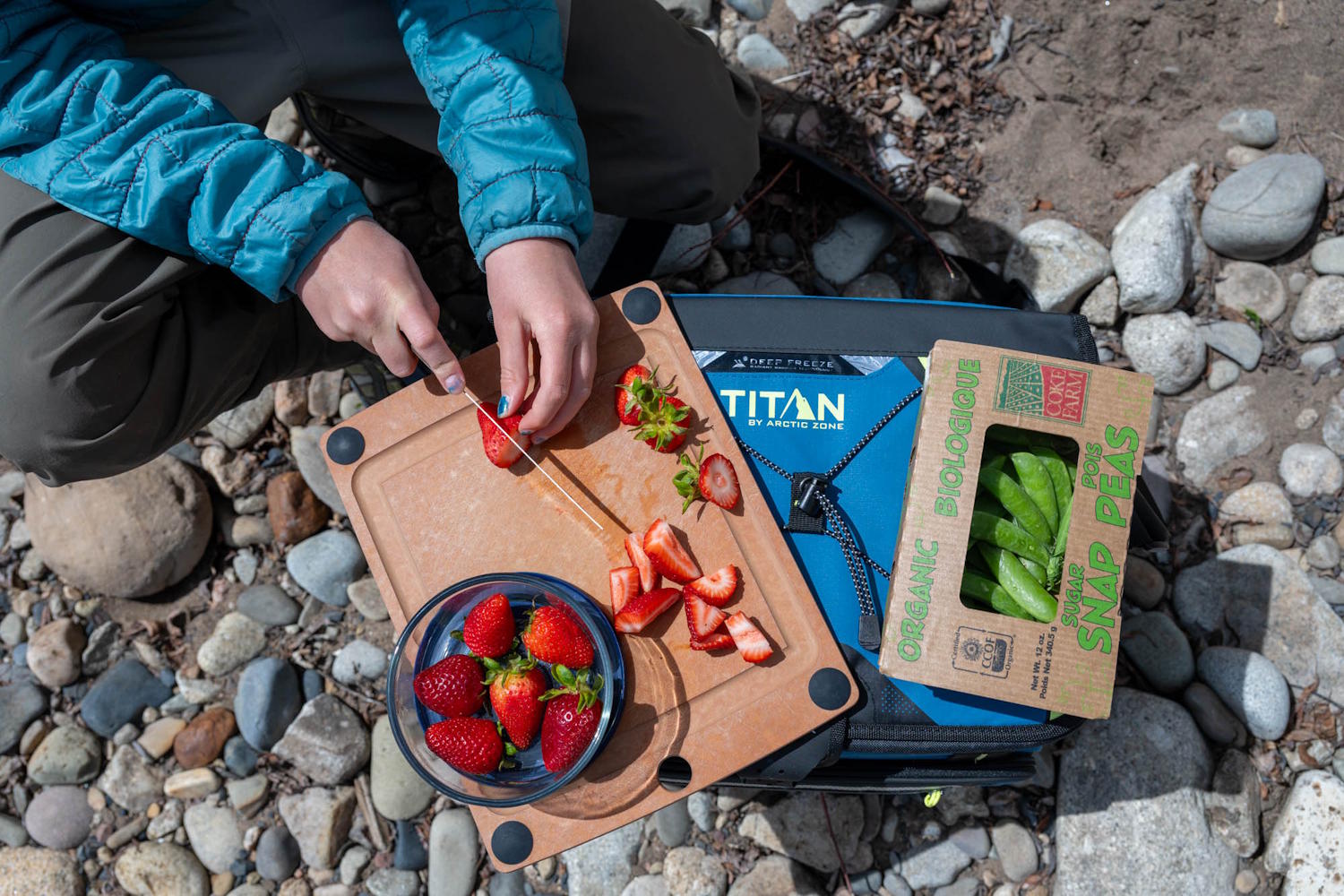 Person slicing strawberries on a Titan by Arctic Zone 30-can cooler