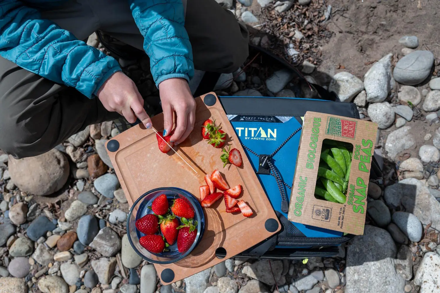 Person slicing strawberries on a Titan by Arctic Zone 30-can cooler