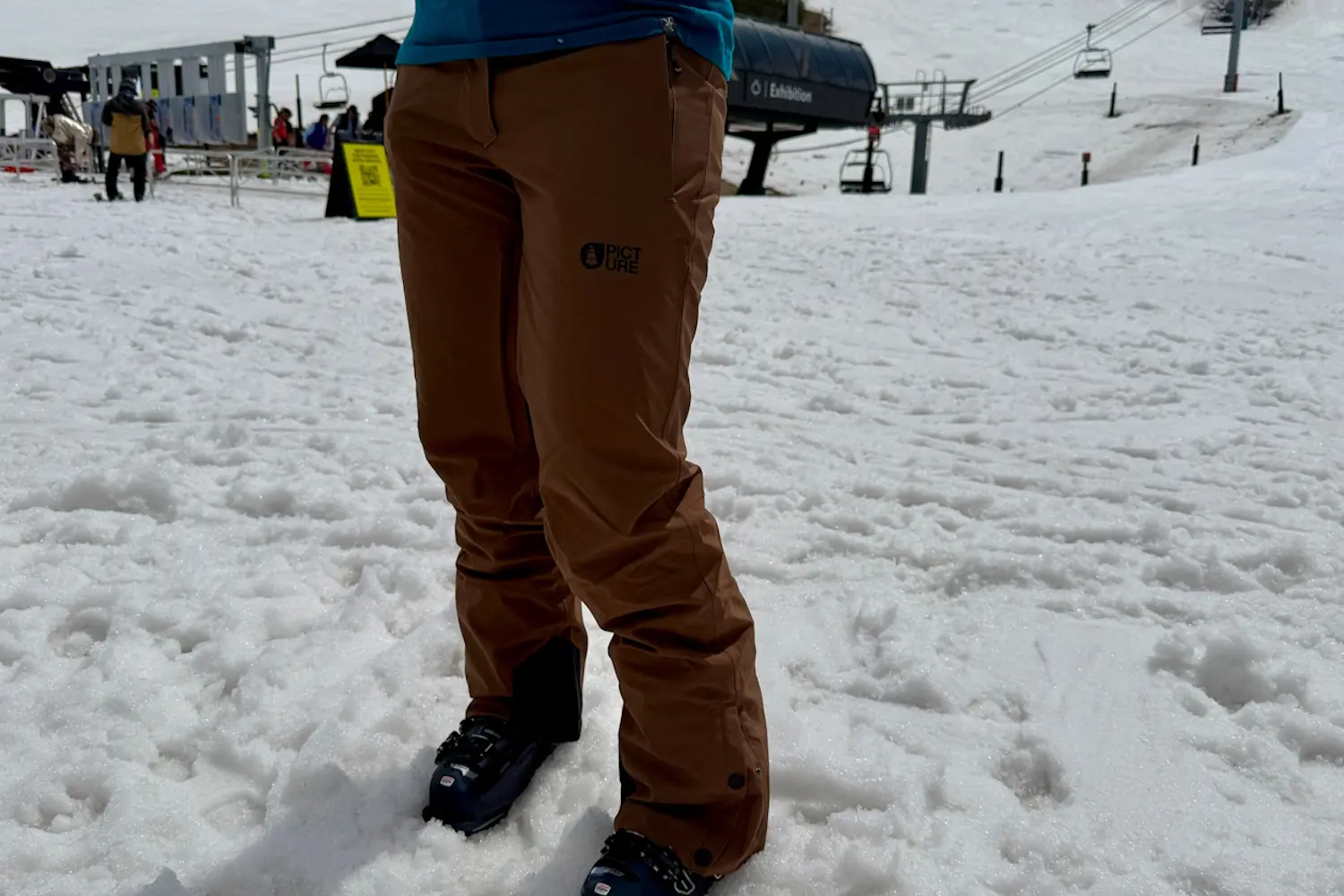Person standing in snow wearing EXA snow pants
