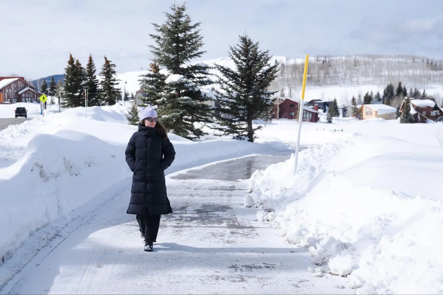 Woman walking outdoors in the snow wearing the Outdoor Research Coze Down Parka