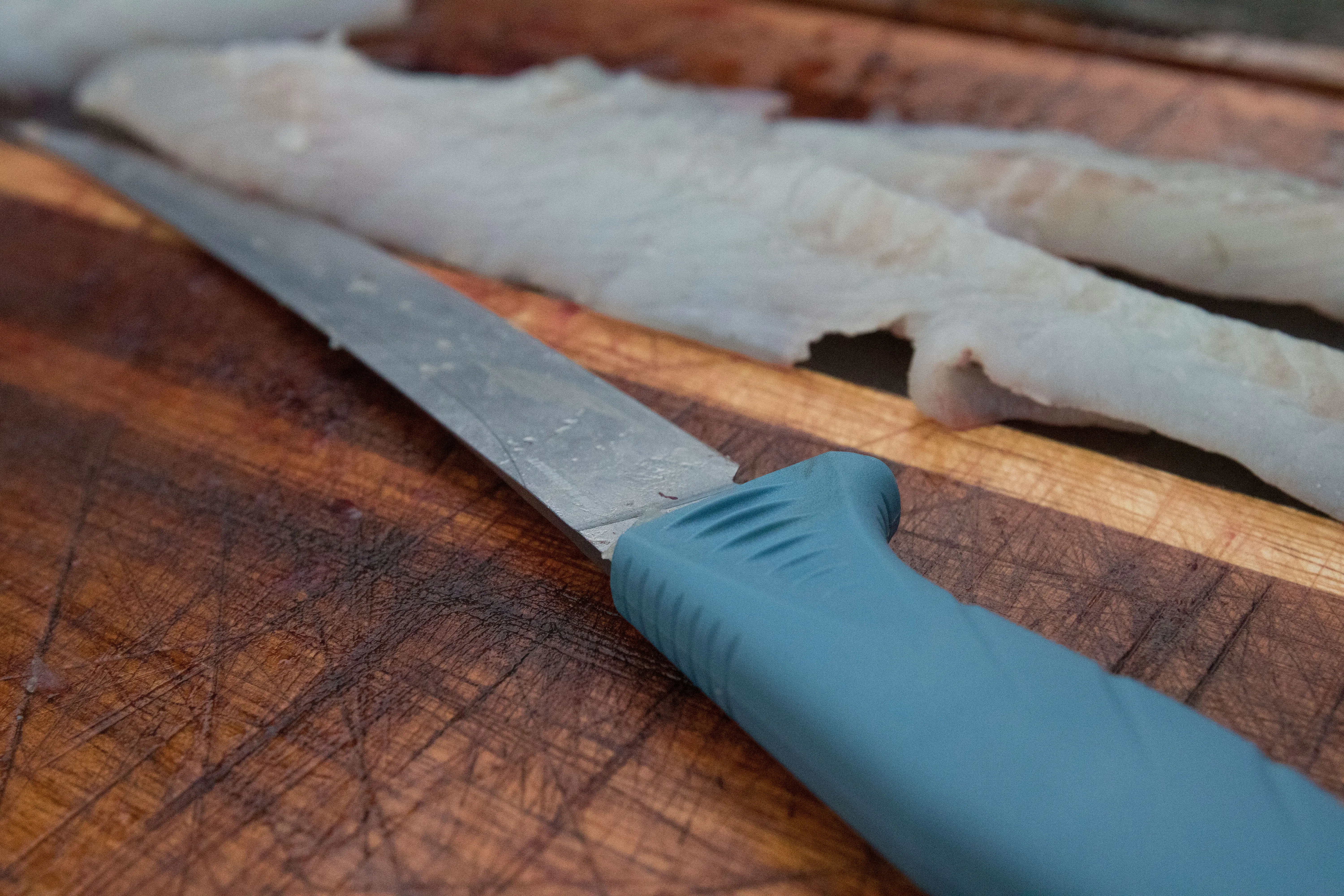 A fillet knife next to fresh fillets