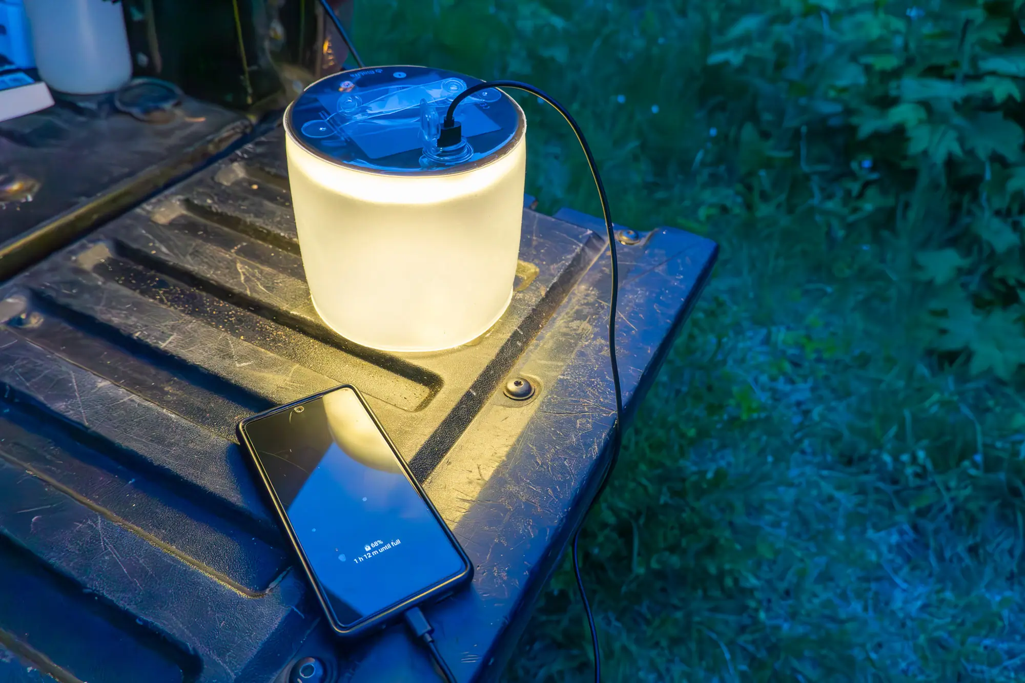 the biolite charge 360 recharges a cell phone on the tailgate of a truck