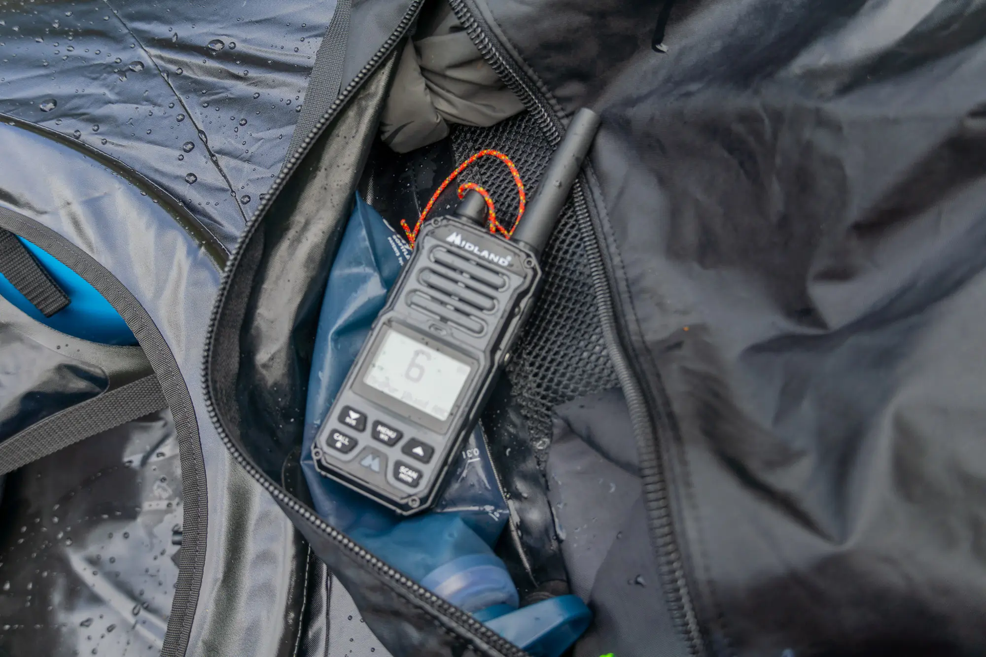 the midland gxt67 pro radio sits on the deck of a packraft