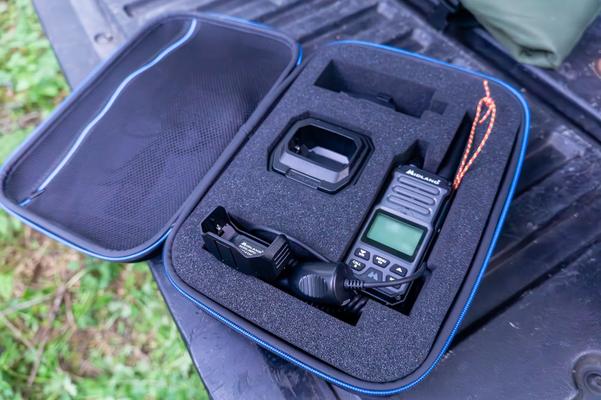 the gxt67 pro radio and accessories sit in its foam-lined case on the tailgate of a truck