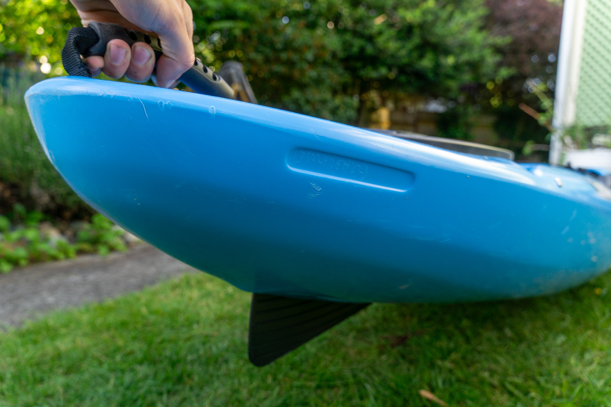 the author holds up the stern of the remix xp, showing the extended skeg in action
