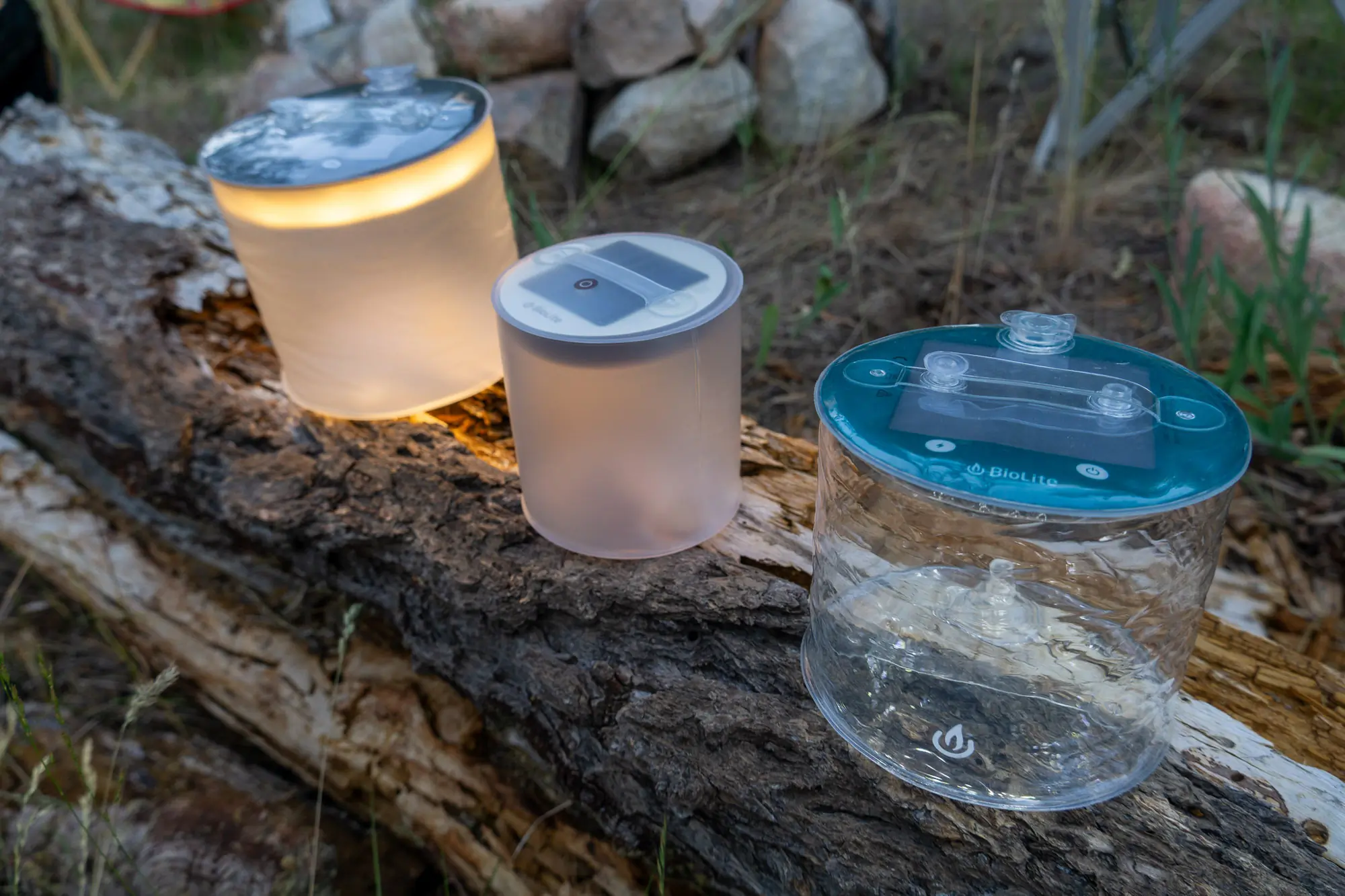 the lineup of biolite luci lanterns set on a log at camp in washington state