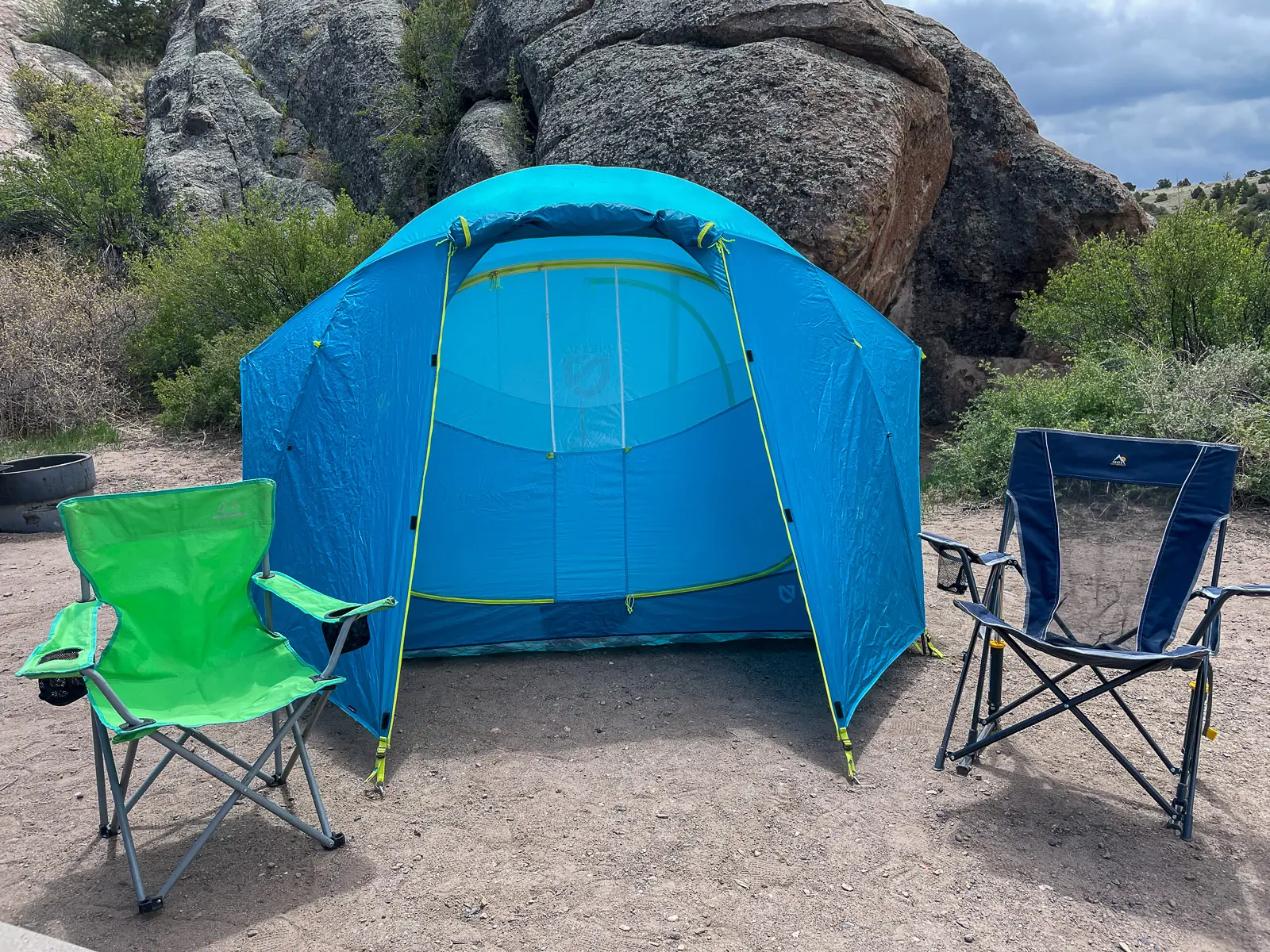 the nemo aurora highrise tent set up with two camp chairs sitting in front of it
