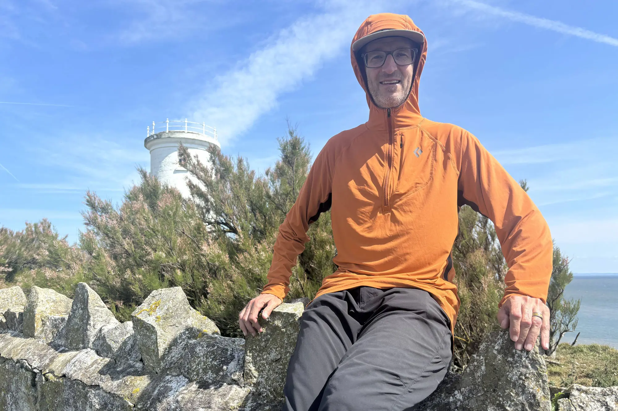 Man wearing Alpenglow Pro Hoody with the hood on