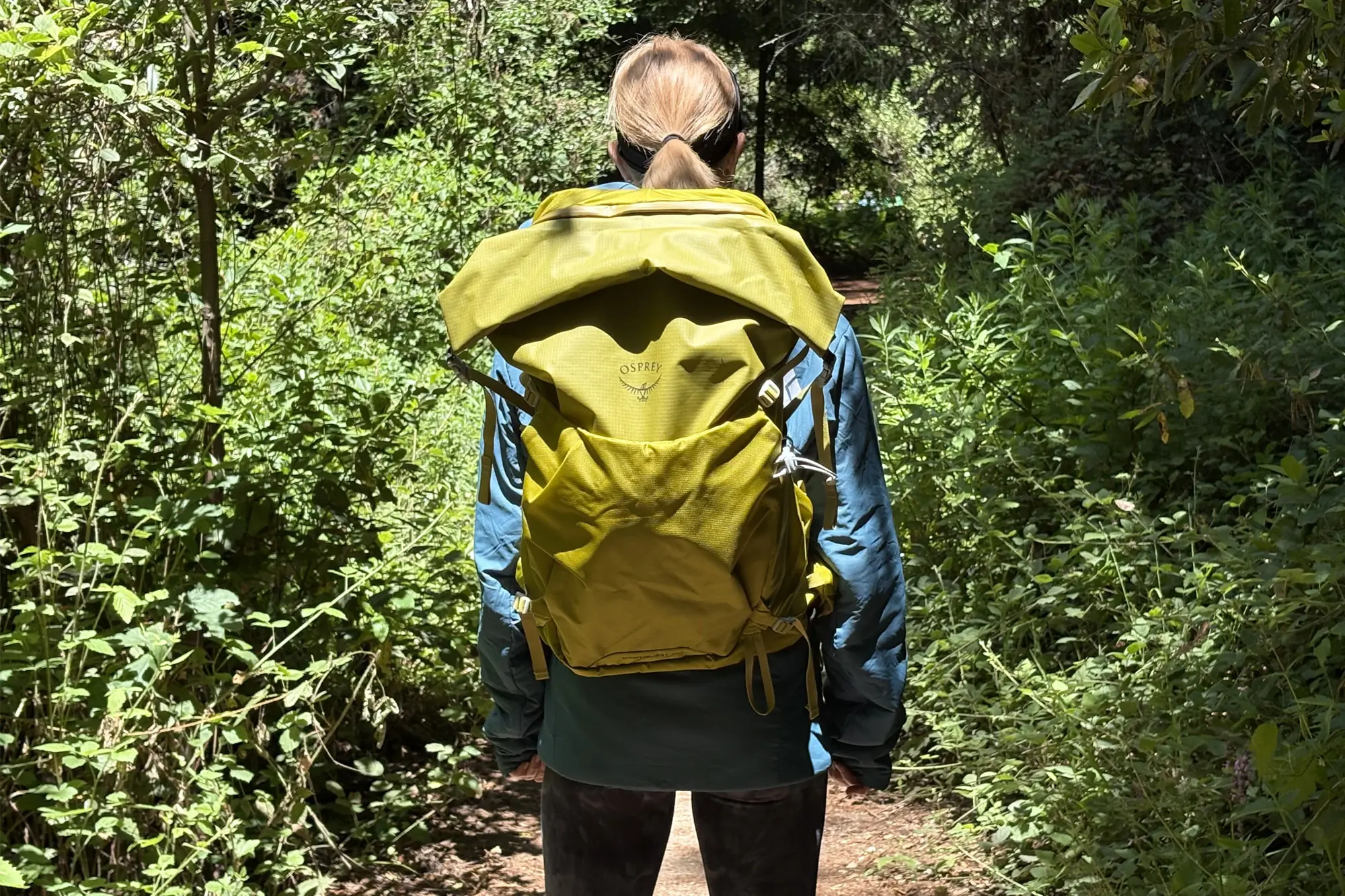 a woman wearing a yellow Osprey Downburst Daypack