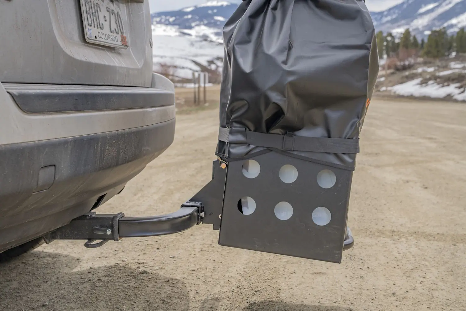 The Gravirax GR-4 rack with waterproof cover is shown mounted to a vehicle’s hitch