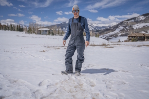 Man wearing Jones Shralpinist Recycled GORE-TEX ePE Bibs standing on a snowy field