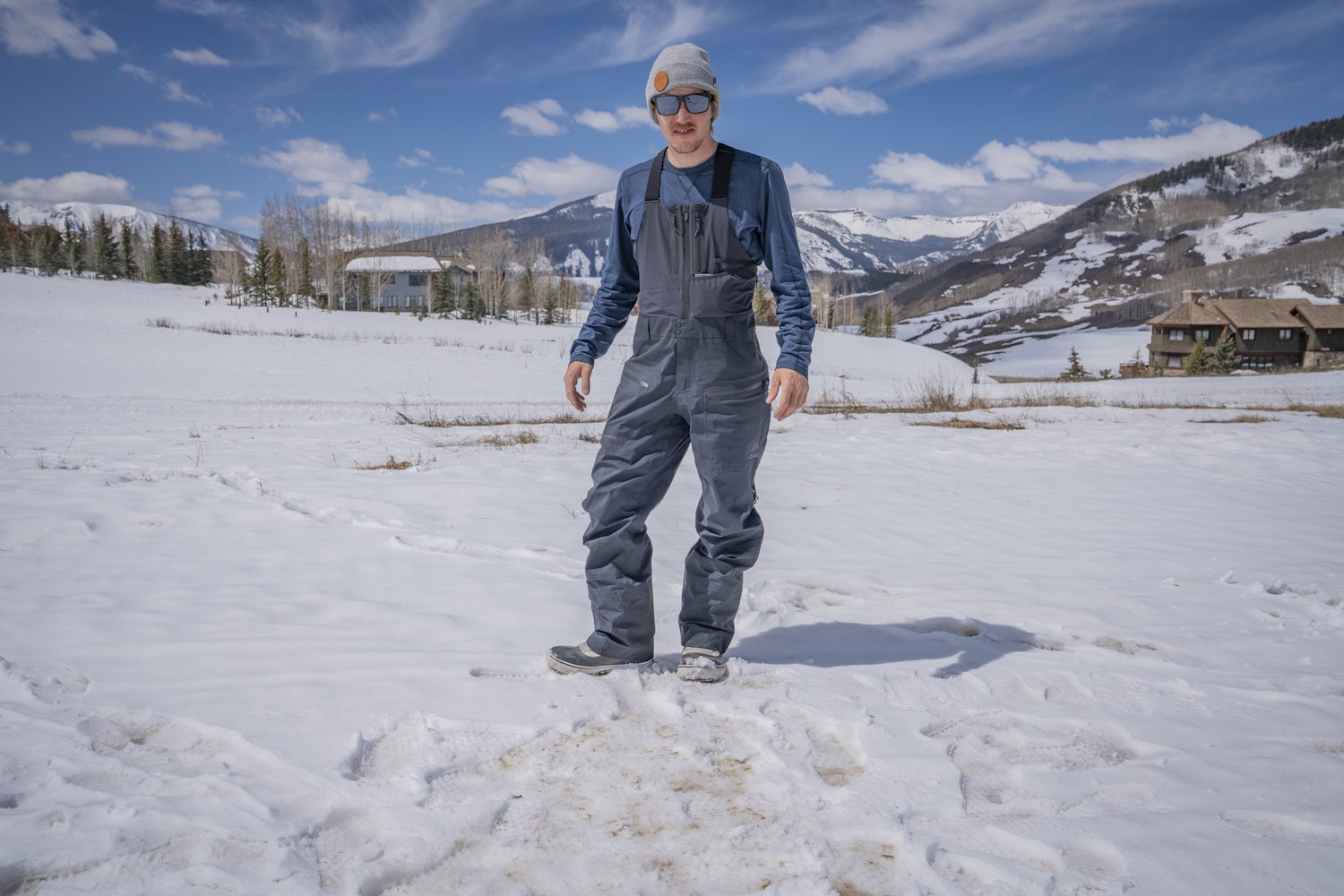 Man wearing Jones Shralpinist Recycled GORE-TEX ePE Bibs standing on a snowy field