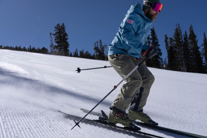 A skier wearing K2 Cortex 130 Zonal BOA boots skis down a snowy slope.
