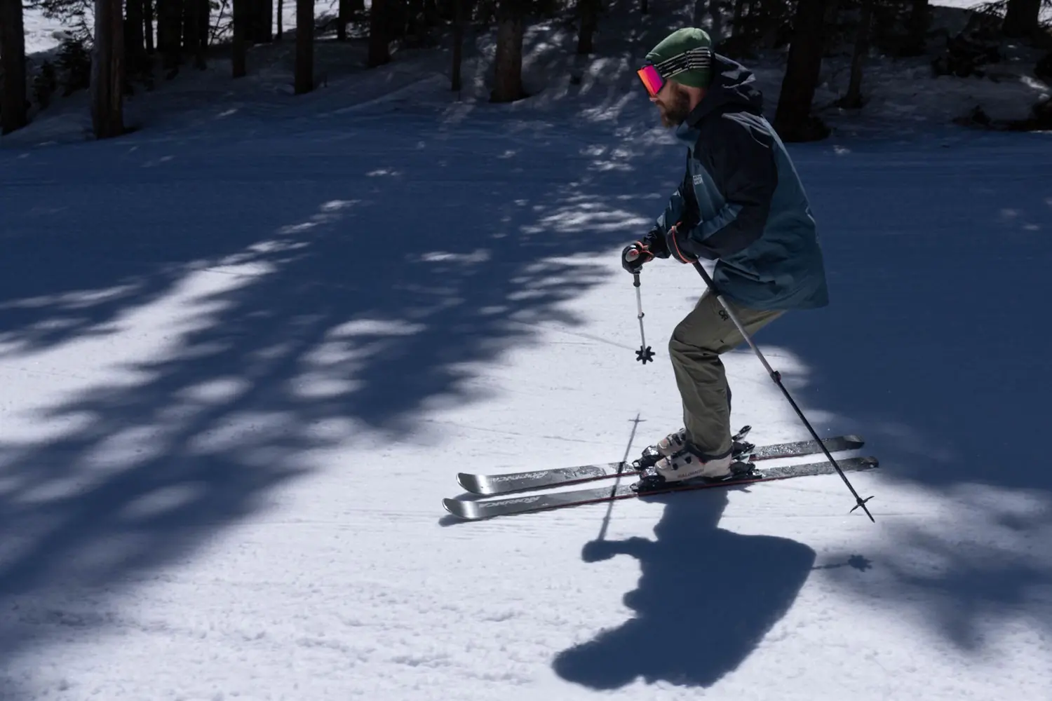Skier wearing Salomon S/Pro Supra 120 Ski Boots skiing through a shaded slope in bright conditions