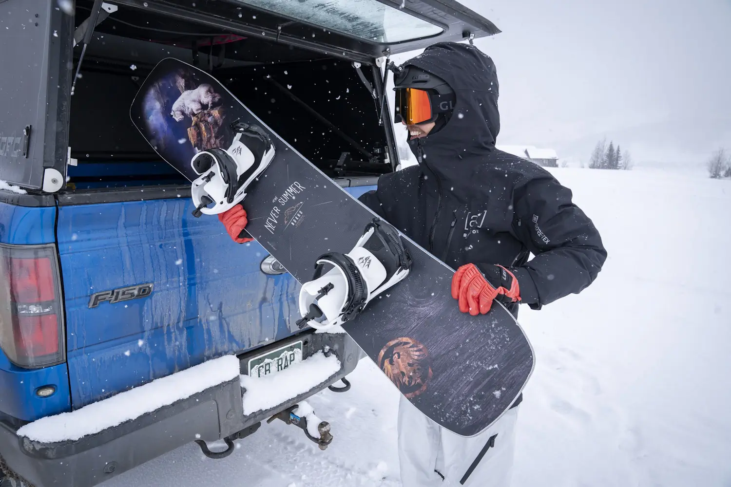 Snowboarder holding a Never Summer snowboard with Jones Mercury FASE bindings