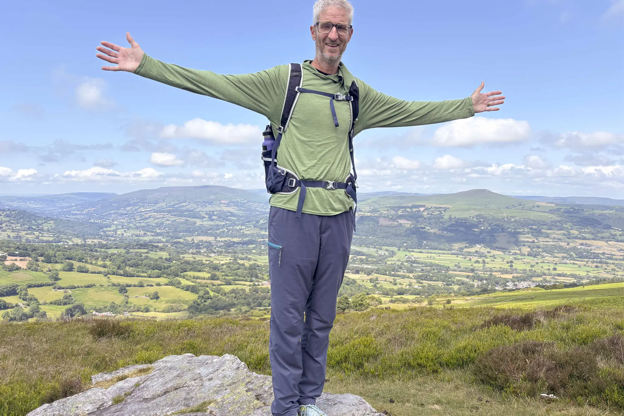 A man standing on a rock wearing REI-Co-op-Trailmade-Pants