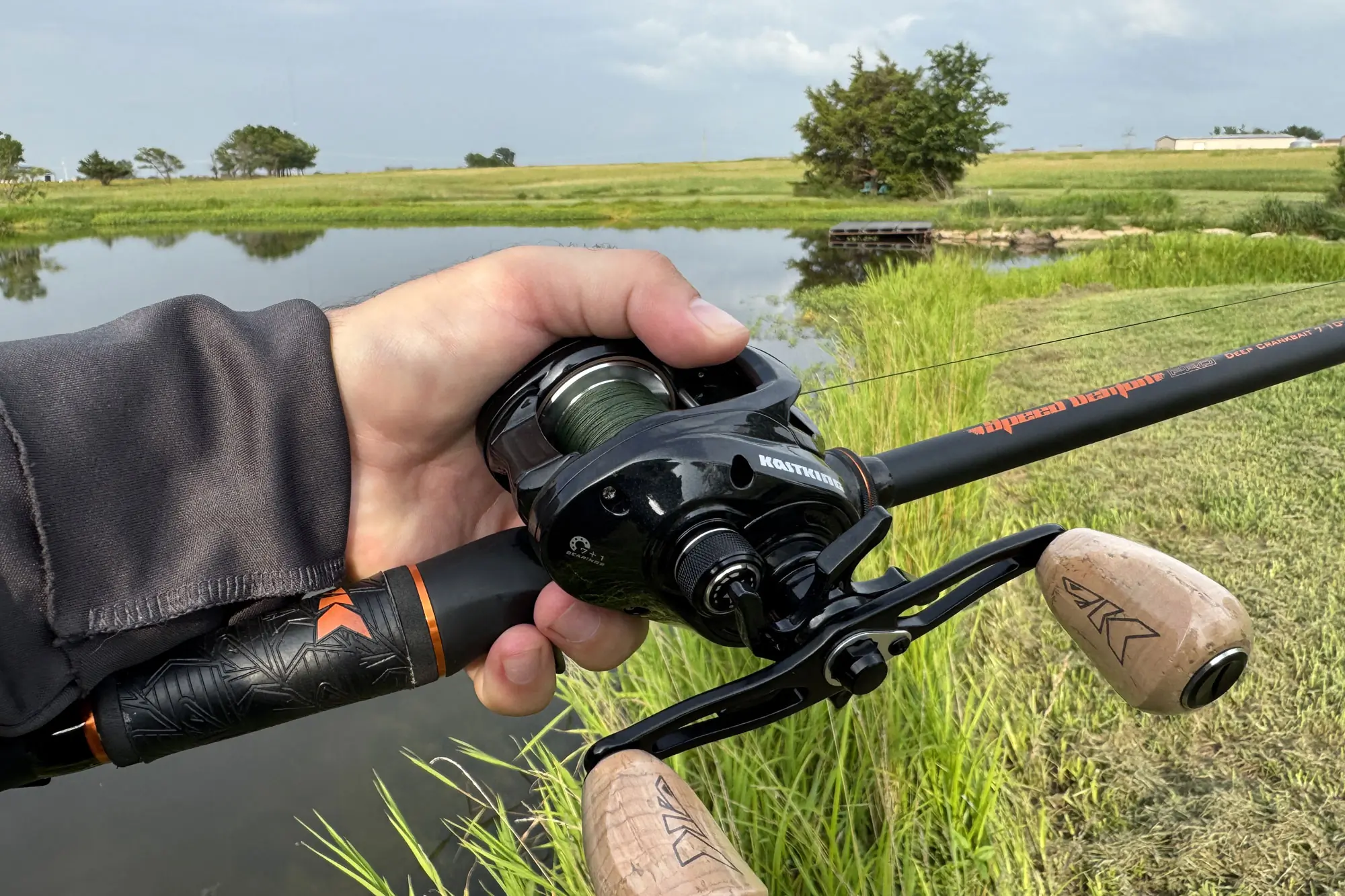 Close-up of the KastKing Megatron 200 reel and rod held over a pond
