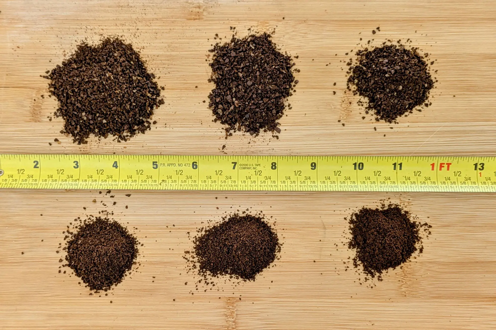 Coffee grind comparison with six piles and a measuring tool