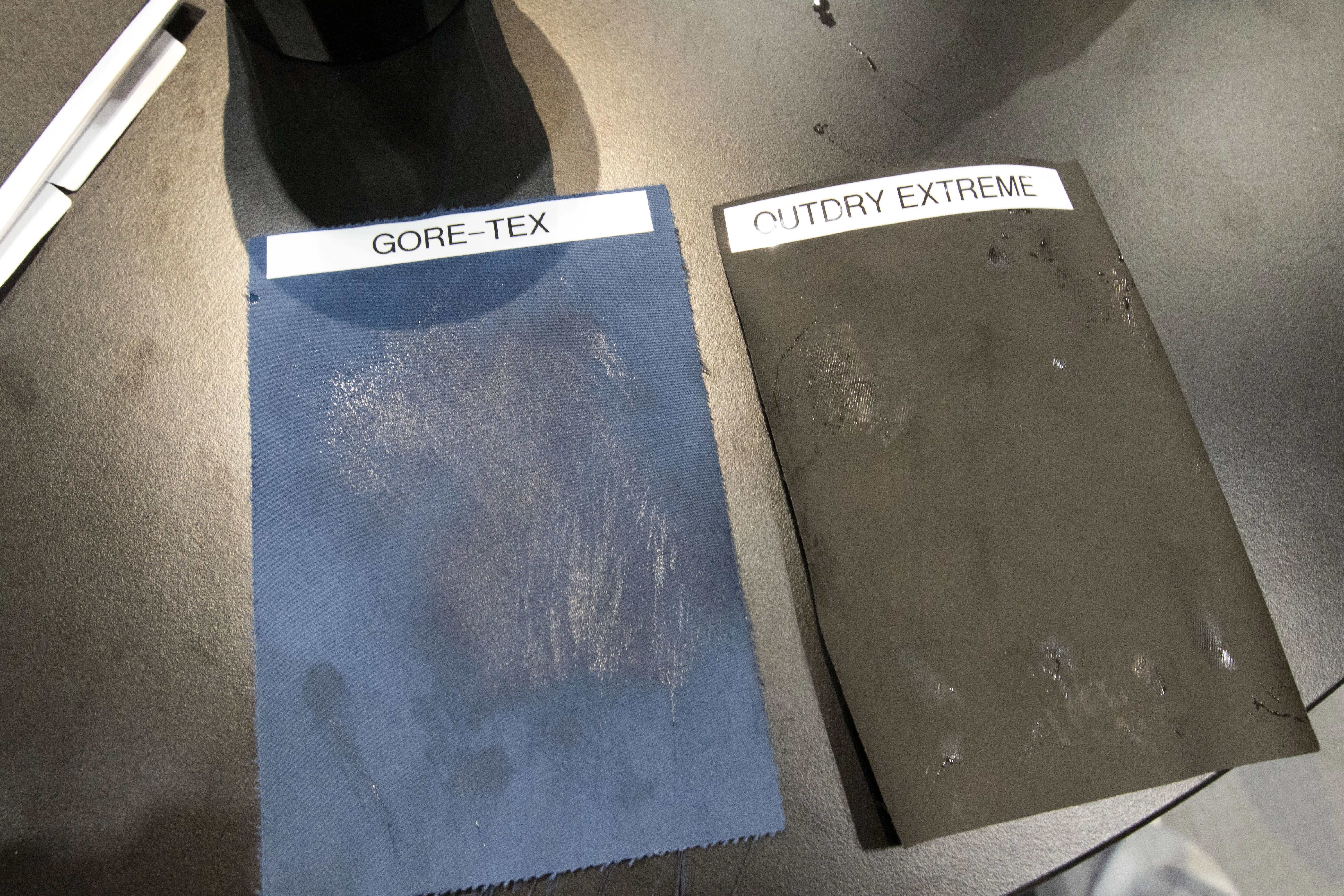 Two waterproof materials side by side, comparing water absorption