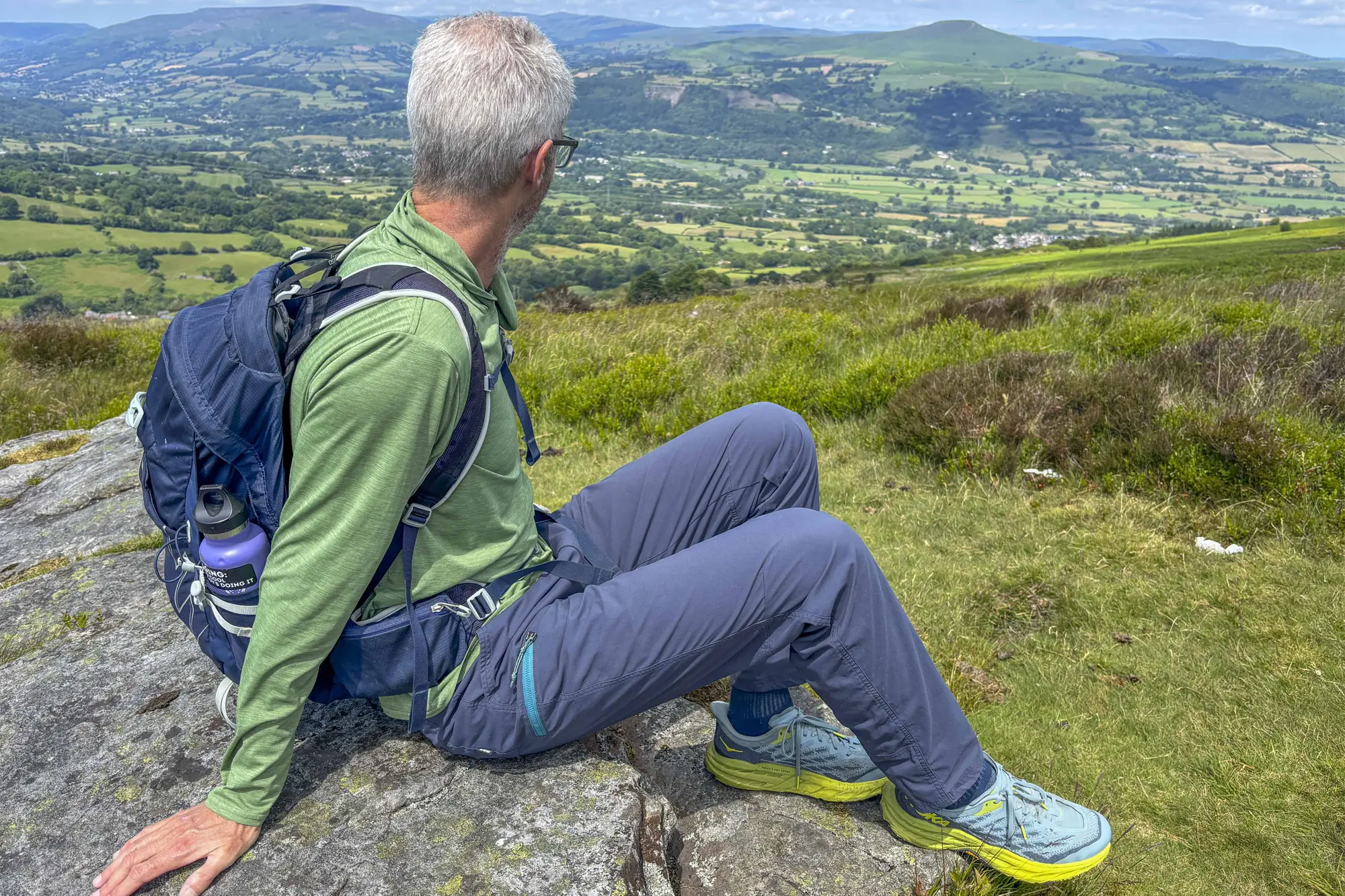 Hiker resting on a rock wearing REI Co-op Trailmade Pants