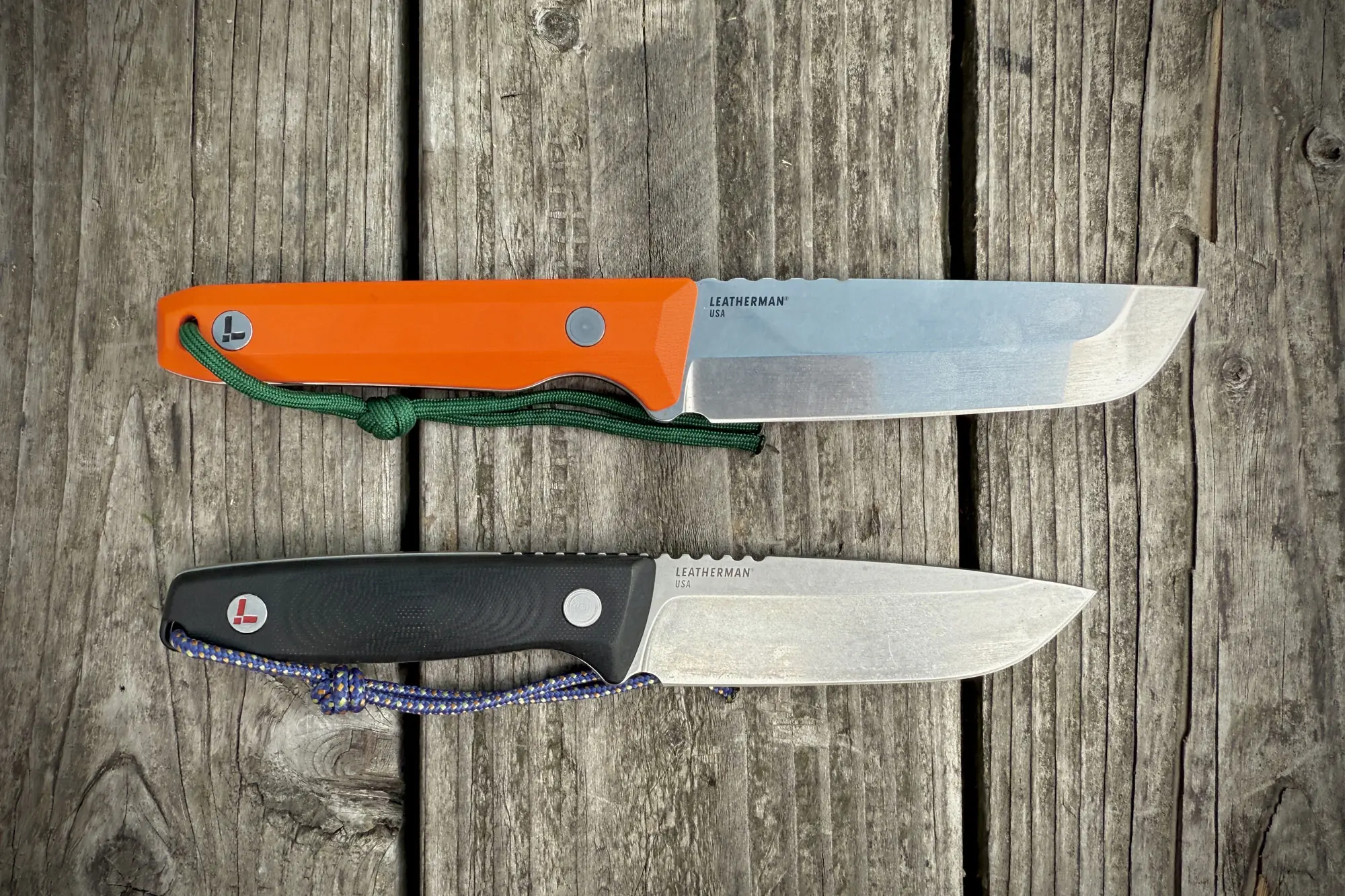 Leatherman Pioneer and Trac knives next to each other on a wooden surface