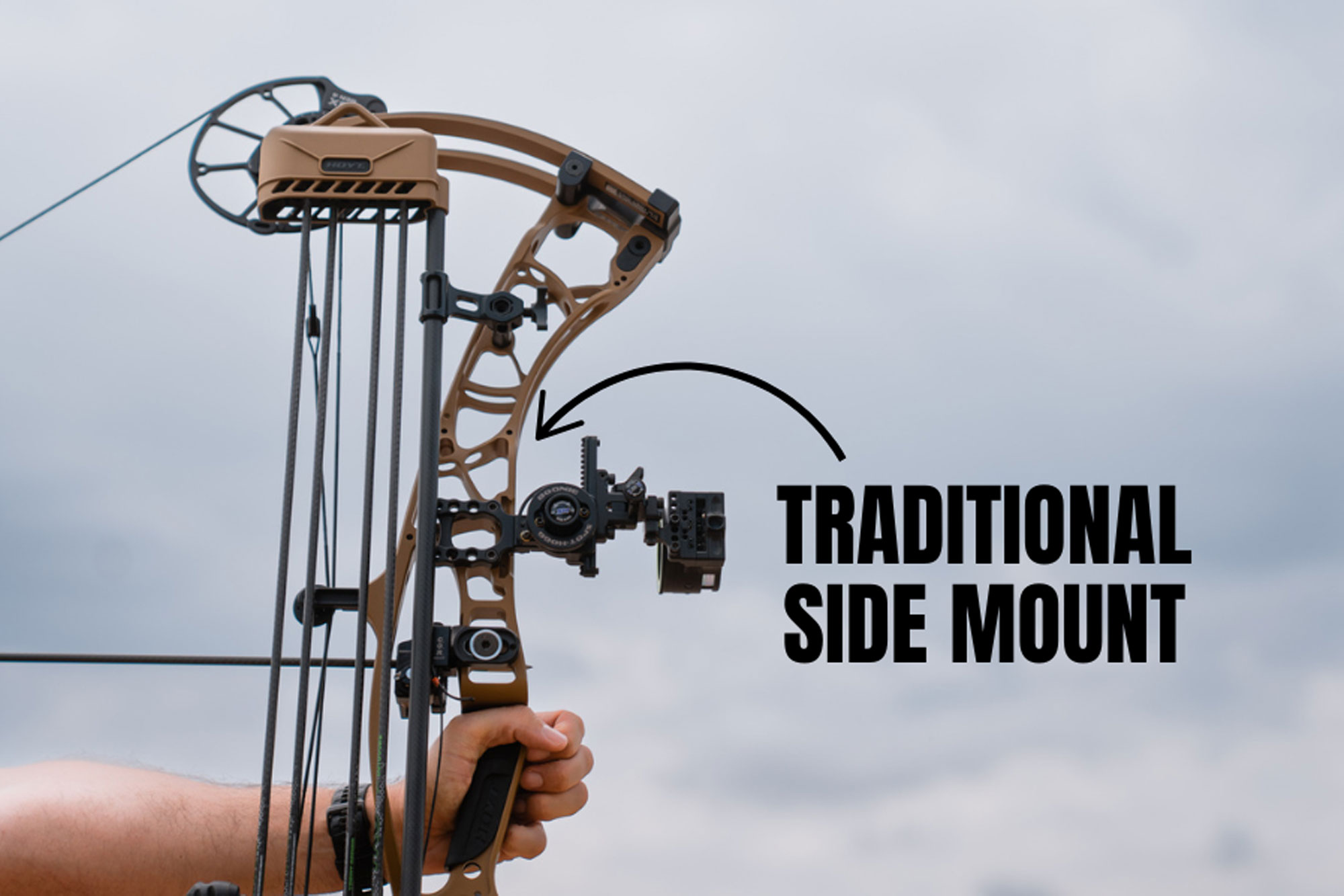 Man holding a bow showing side mount