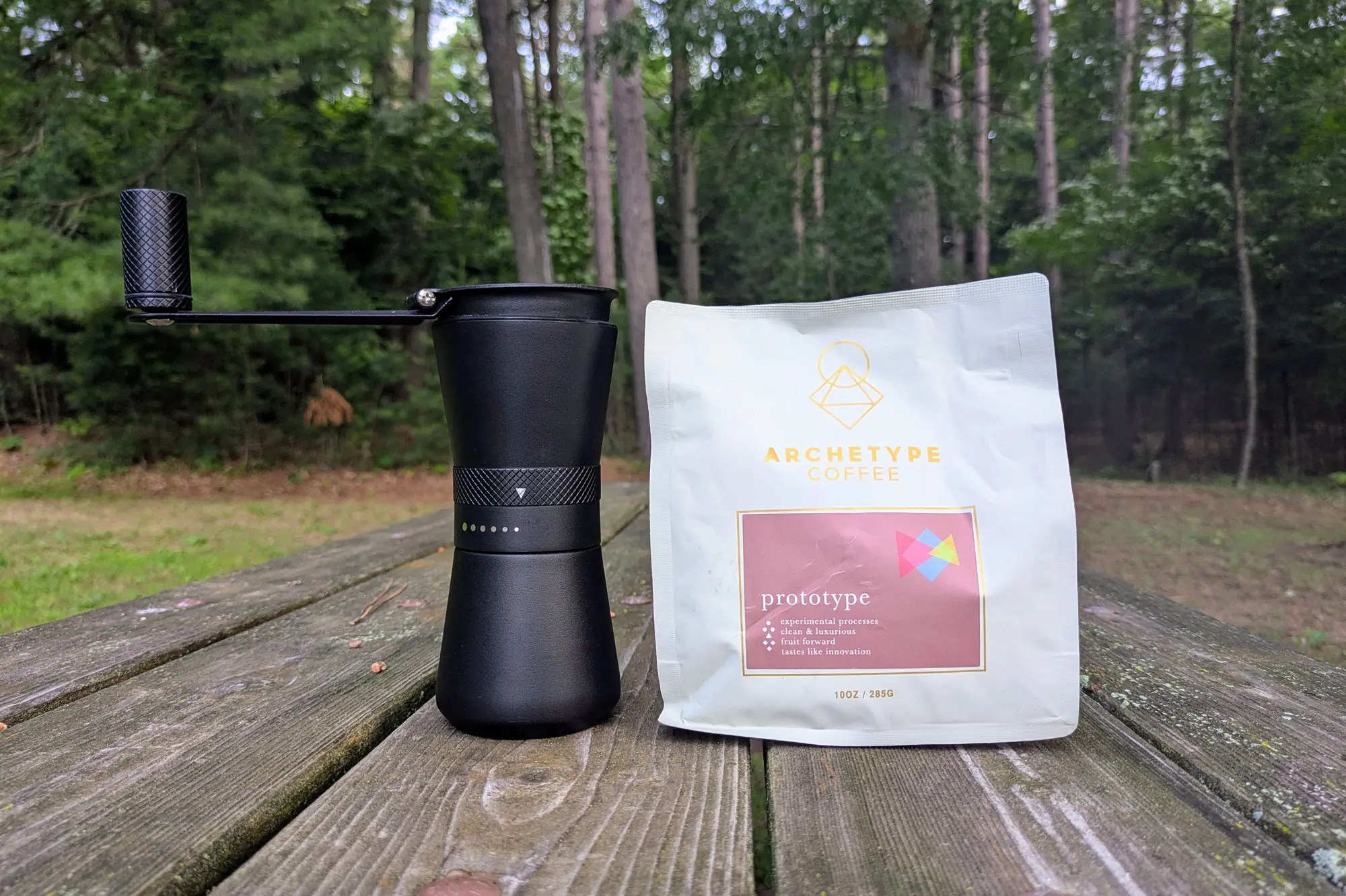 MiiR Grinder and Archetype coffee on a wooden table in nature