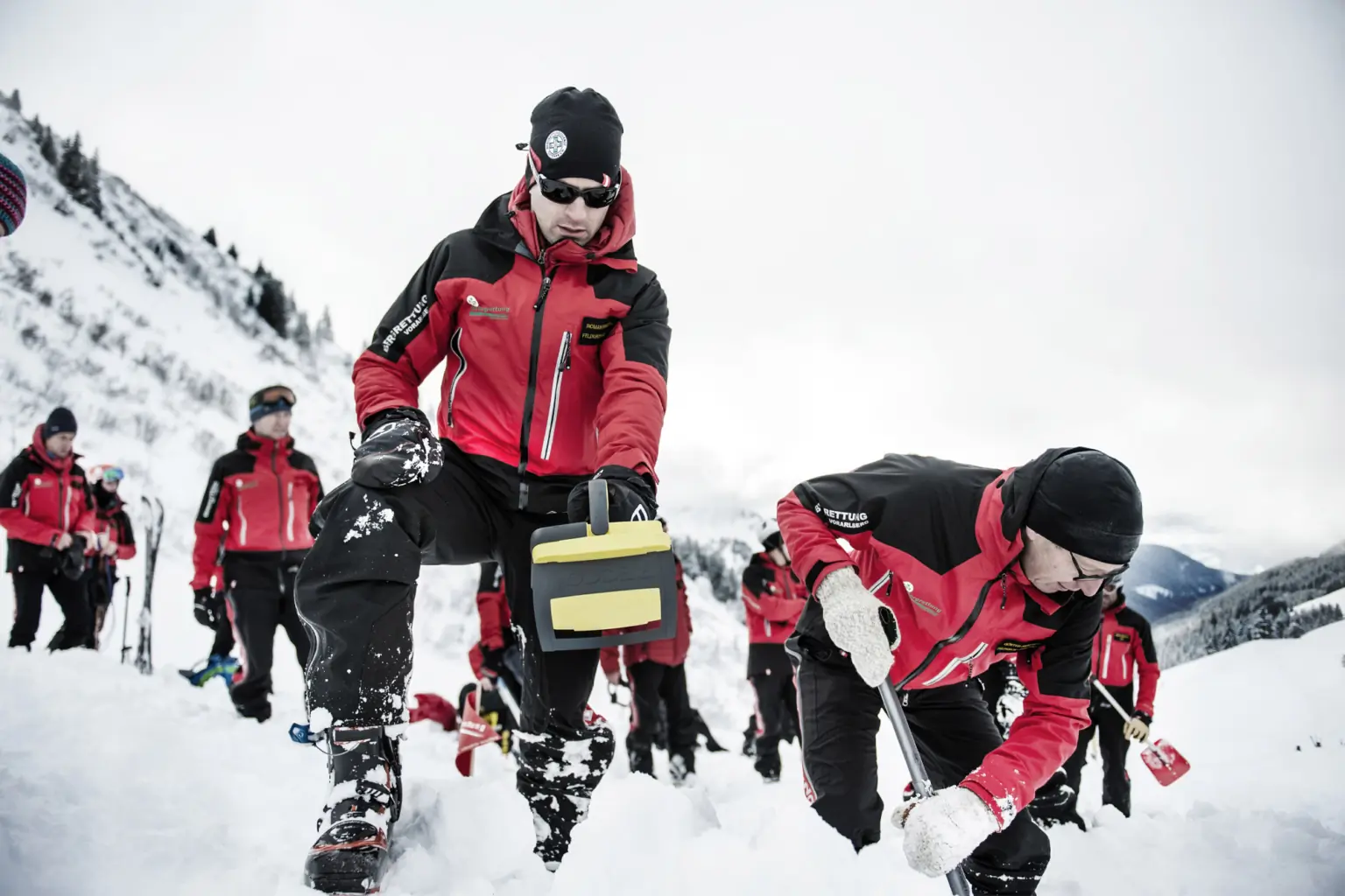 Mountain rescuers use a RECCO handheld device in the snow